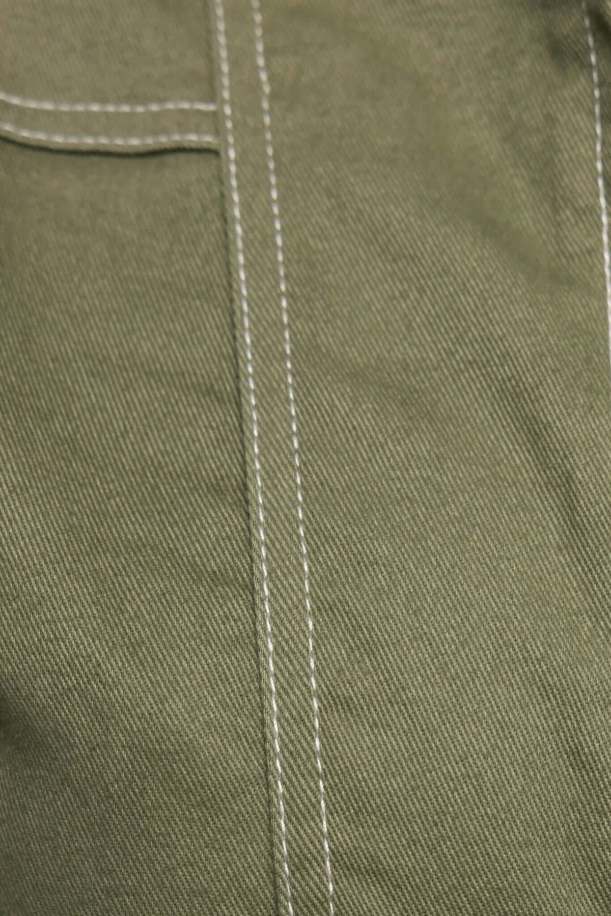 Close-up of jade denim fabric showcasing texture and sewing detail, perfect for stylish playsuits.
