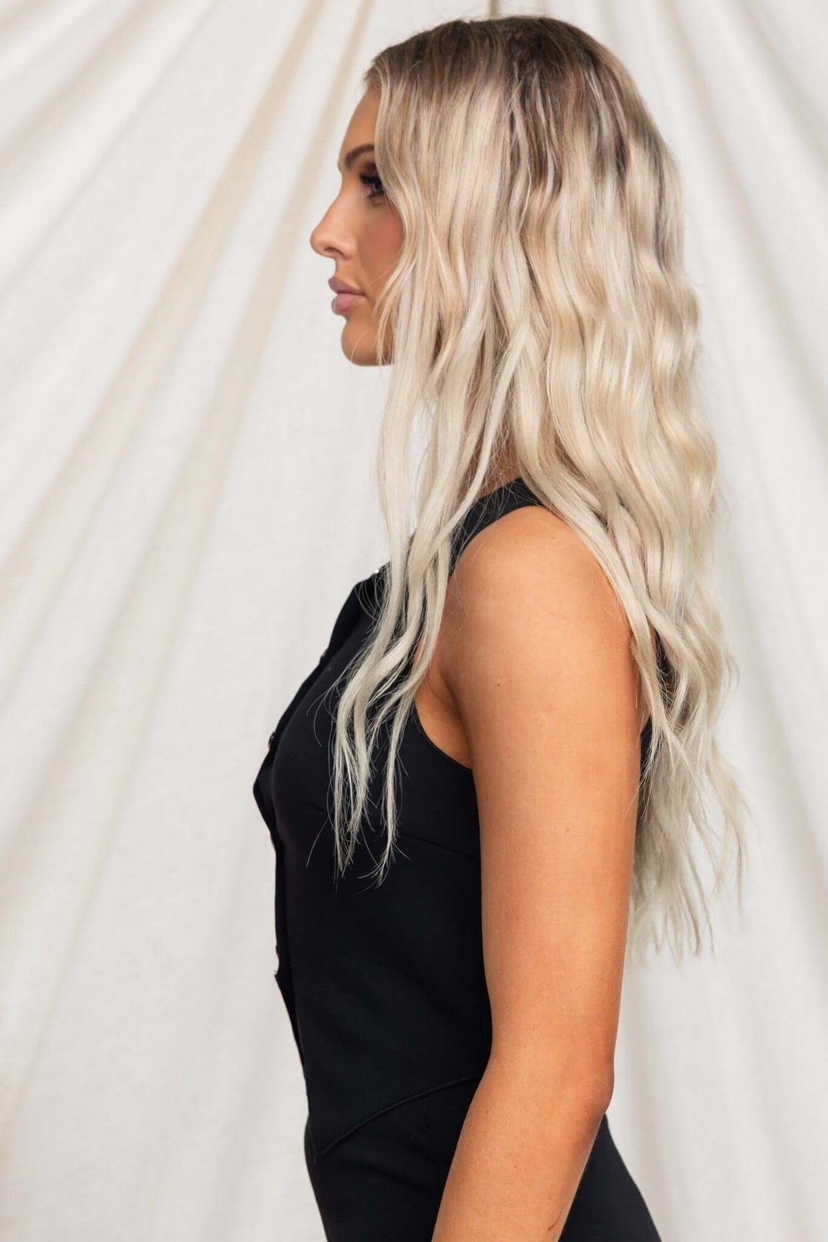 Model wearing Summit Top in black, showcasing a vest style with button-up front and lightly ribbed material.