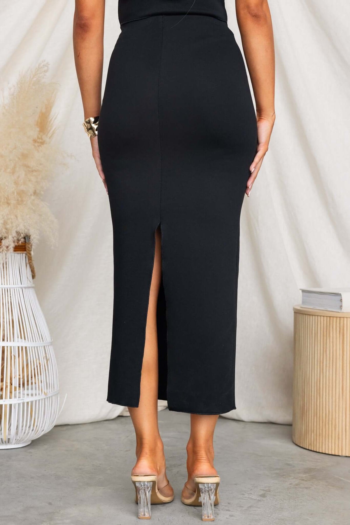 Back view of Summit Midi Skirt showing mid-high waist, split detail, and stretchy fabric for a chic look.