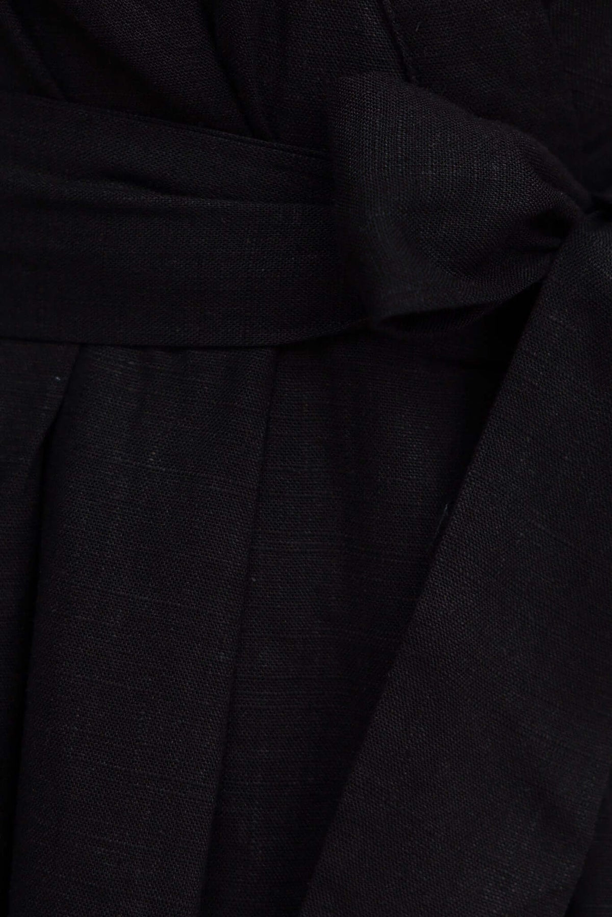 Close-up of black Hosier Playsuit waist with removable tie detail and textured fabric.