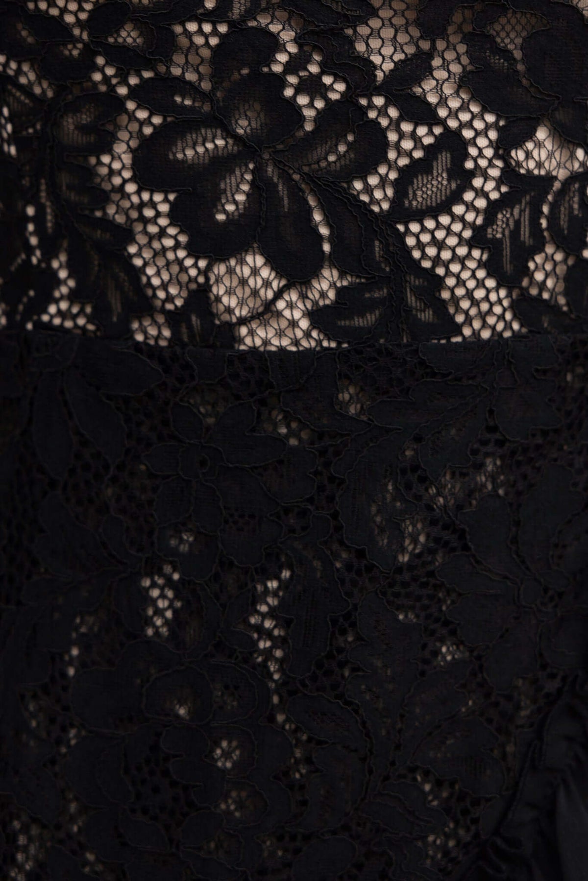 Close-up of lace fabric featuring floral patterns on the Elie Dress, highlighting the intricate detailing and texture.