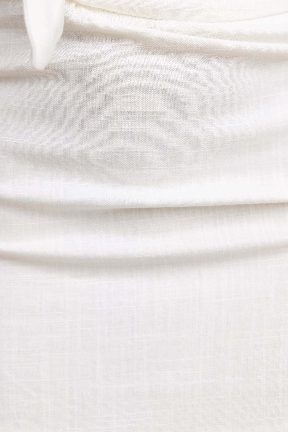 Close-up of the Adami Skirt showing a mid-high waist fit with a tie detail and smooth, lined fabric.