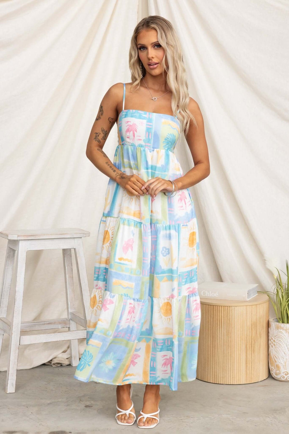 Model wearing a colorful Waterloo Maxi Dress with adjustable straps and pockets against a neutral backdrop.