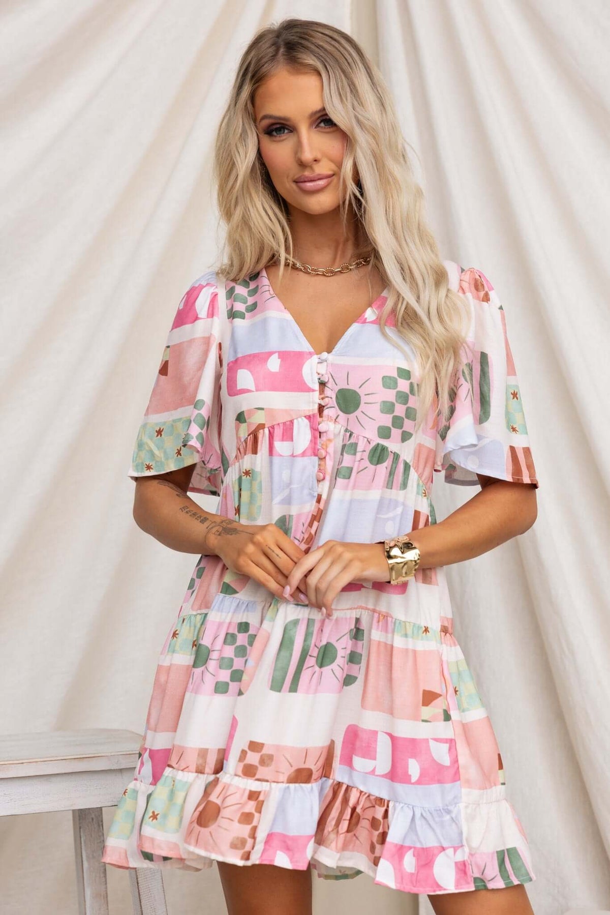 Model wearing Mariella Dress with button-up front and pockets, featuring a colorful patterned design.
