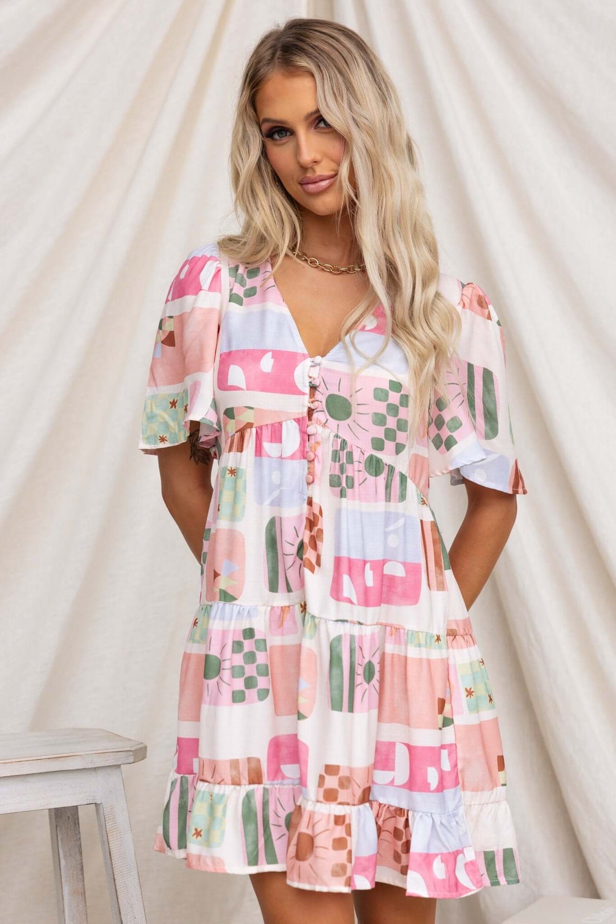 Mariella Dress with colorful patterns, button-up front, short sleeves, and tiered layers, perfect for casual summer outings.