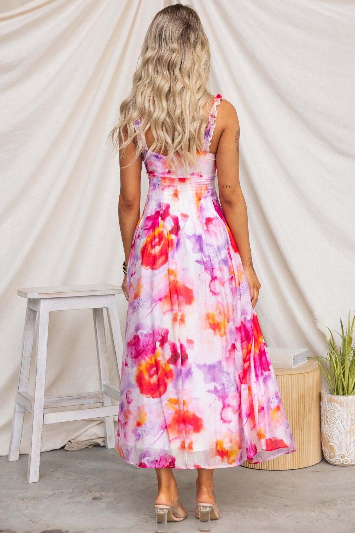 Back view of Estelle Midi Dress with elastic straps and colorful floral print, perfect for summer occasions.