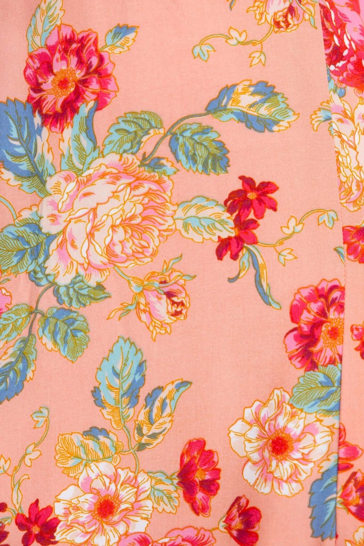 Floral fabric design featuring vibrant pink, blue, and yellow flowers on a soft peach background for Briony Maxi Dress.