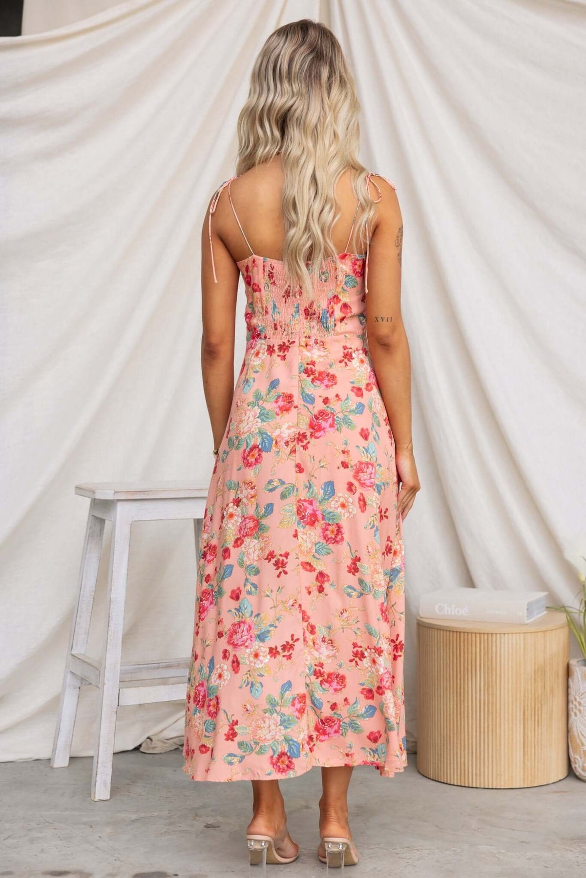 Back view of the Briony Maxi Dress featuring floral print, adjustable spaghetti straps, and split hem.