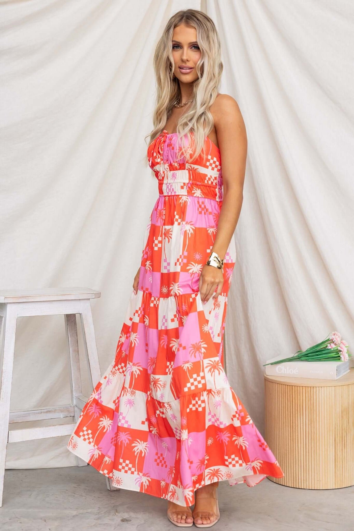 Norment Maxi Dress featuring thin adjustable straps, tie detail, and a vibrant pink and orange palm print design.