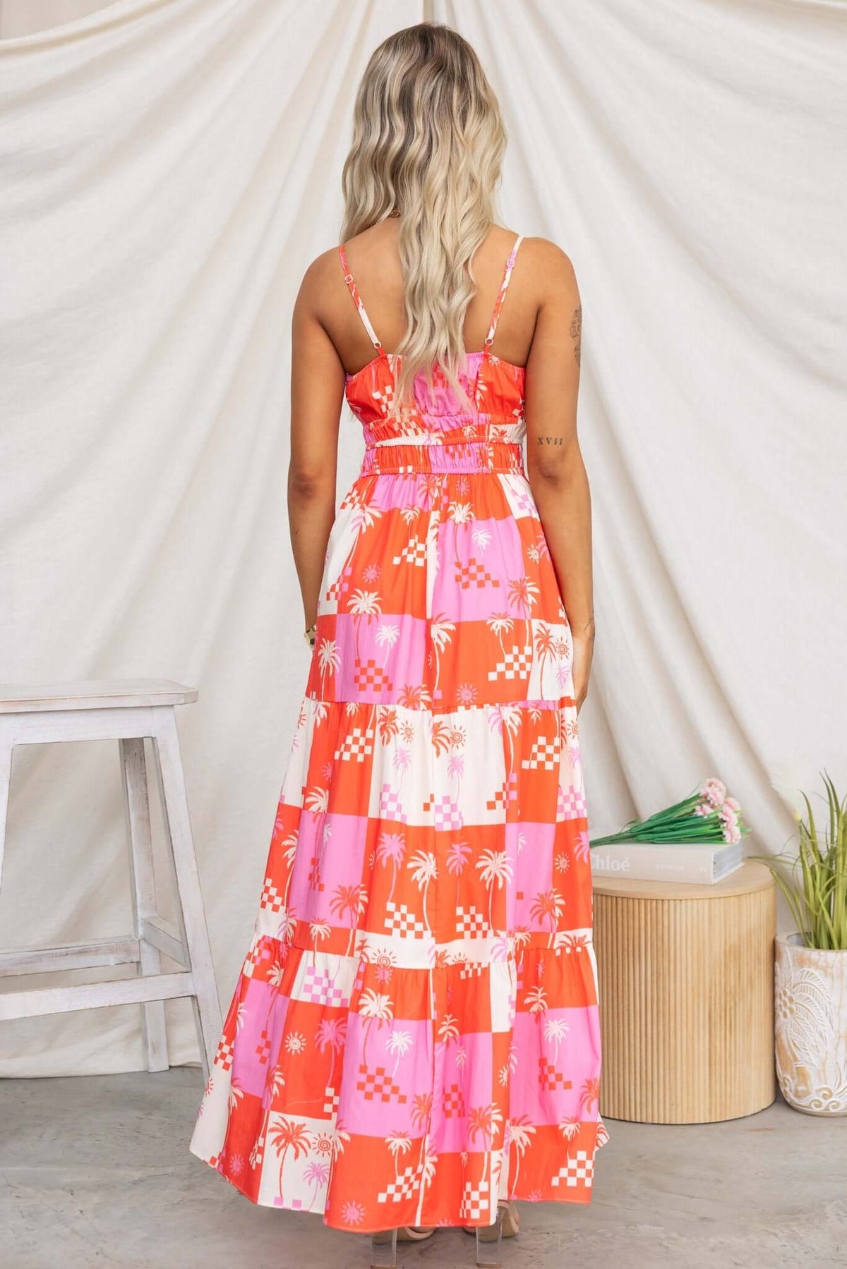 Woman wearing Norment Maxi Dress in colorful pattern, showcasing adjustable straps and tiered skirt.