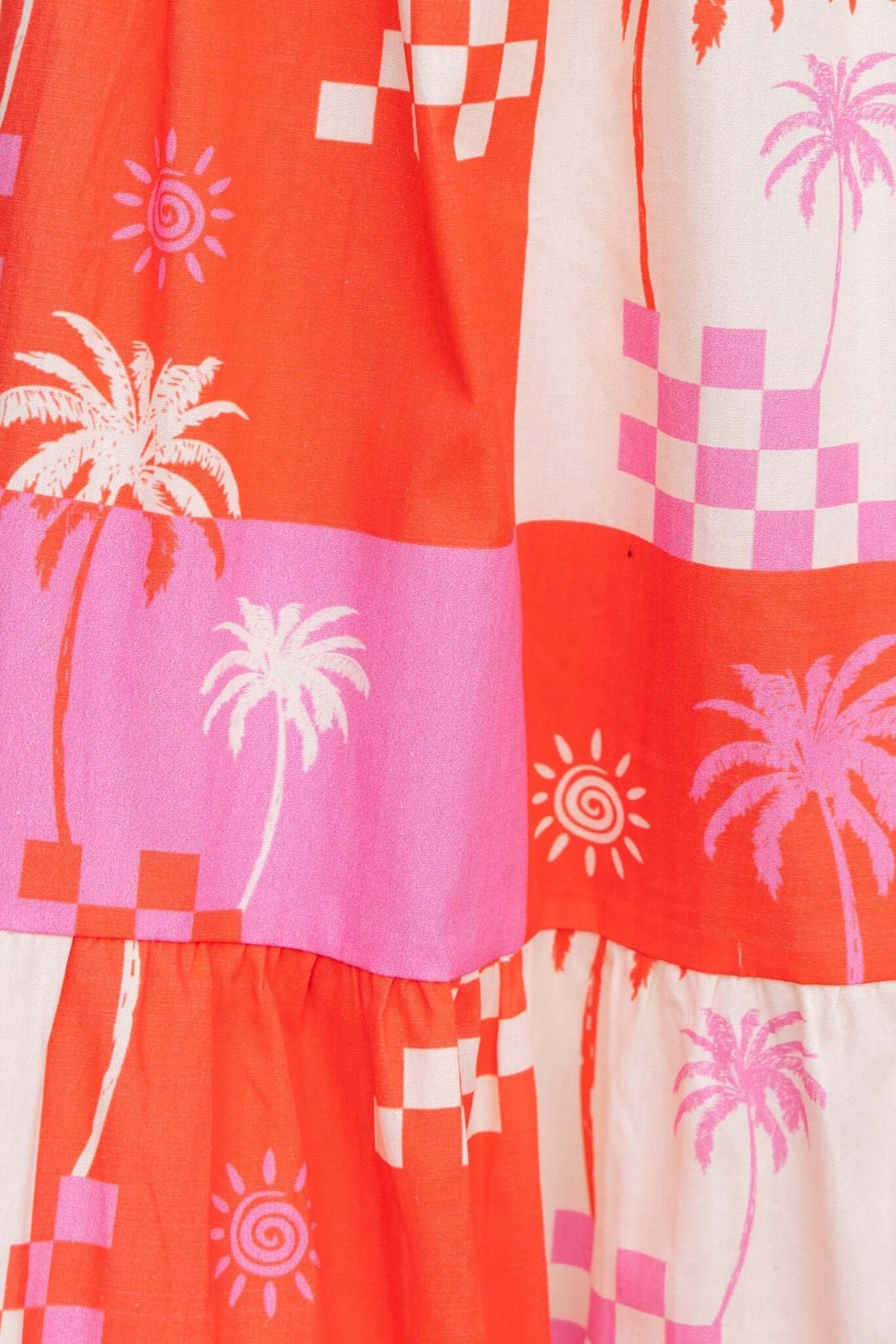 Close-up of the vibrant Norment Maxi Dress featuring palm tree and checkerboard patterns in orange and pink.