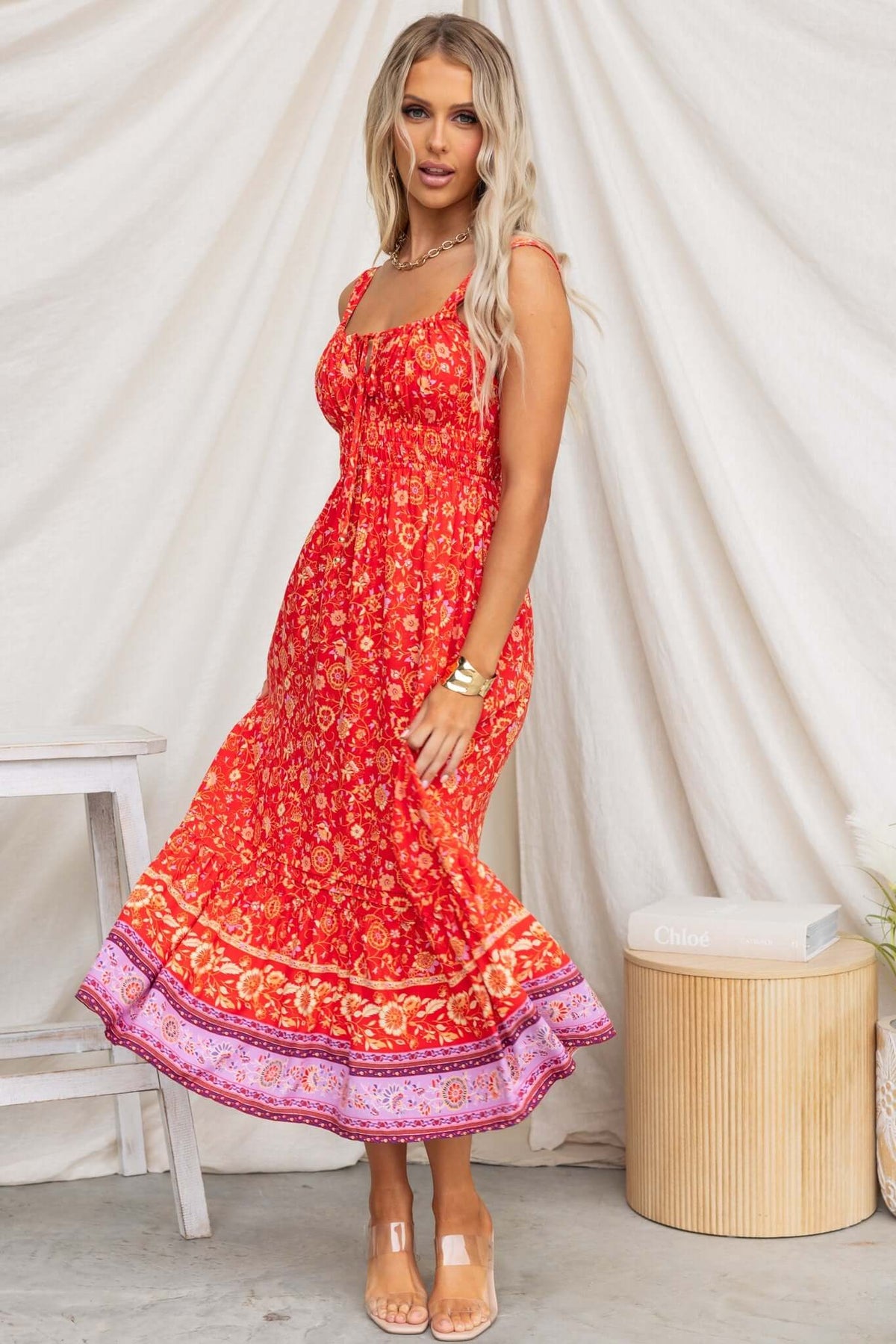 Skipper Midi Dress in vibrant red floral print with adjustable straps and elastic waist, perfect for summer styling.