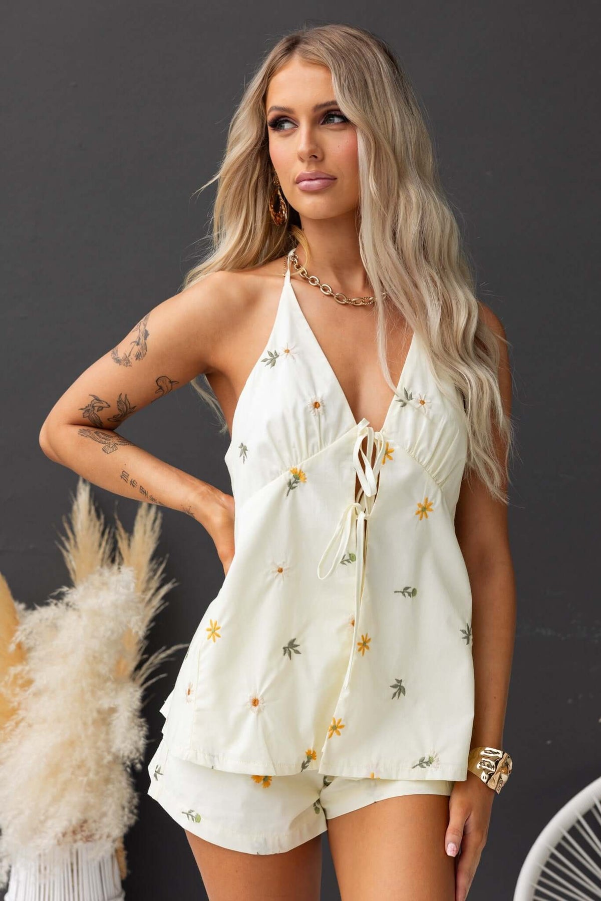 Model wearing Tori Shorts with a floral top, featuring a mid-high waist and elastic waistband, perfect for summer styling.