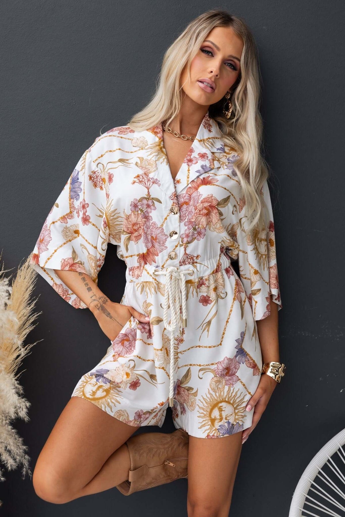 Stylish Fiddler Playsuit with floral pattern, collar, button-up front, and relaxed fit worn by model.