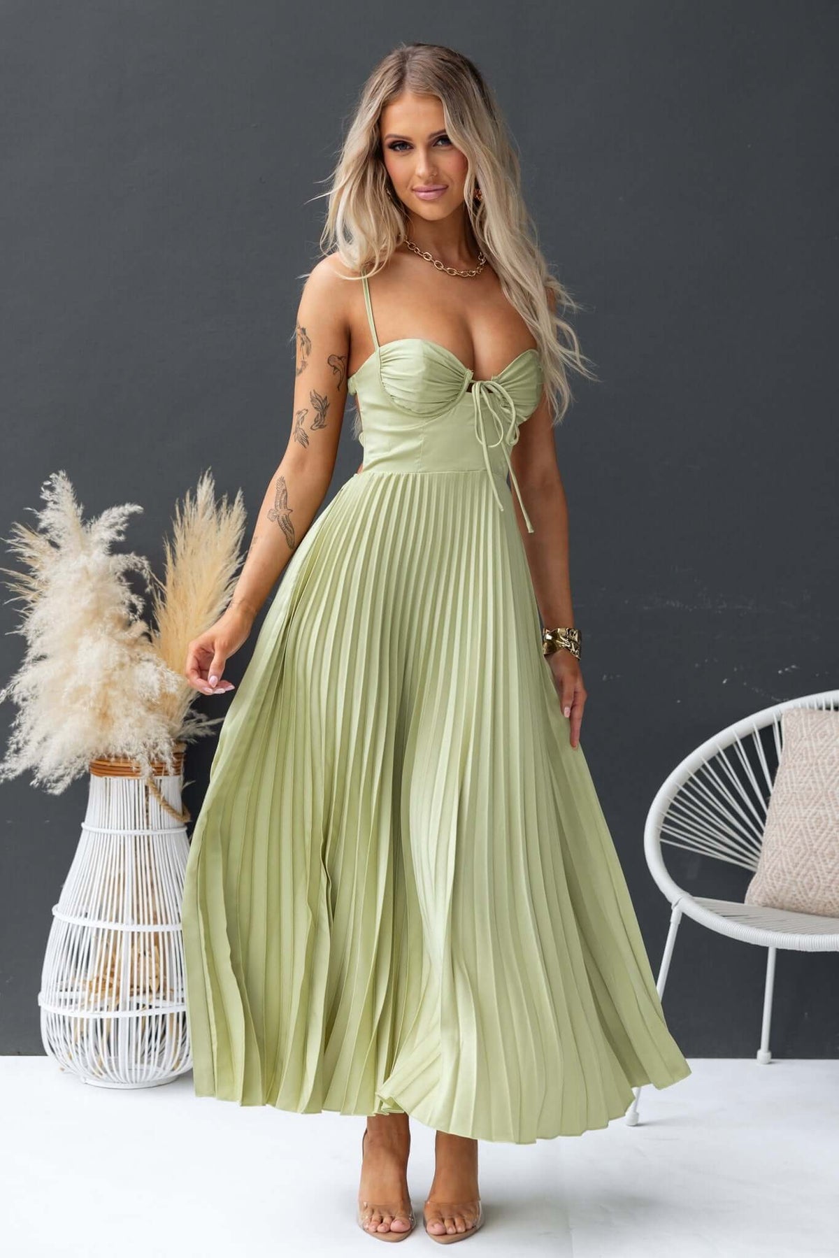 Model in a pleated mint green Danette Maxi Dress with adjustable straps and side zip, styled with boho accessories.