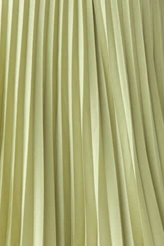 Close-up of pleated fabric in soft green, showcasing the elegant texture of the Danette Maxi Dress.