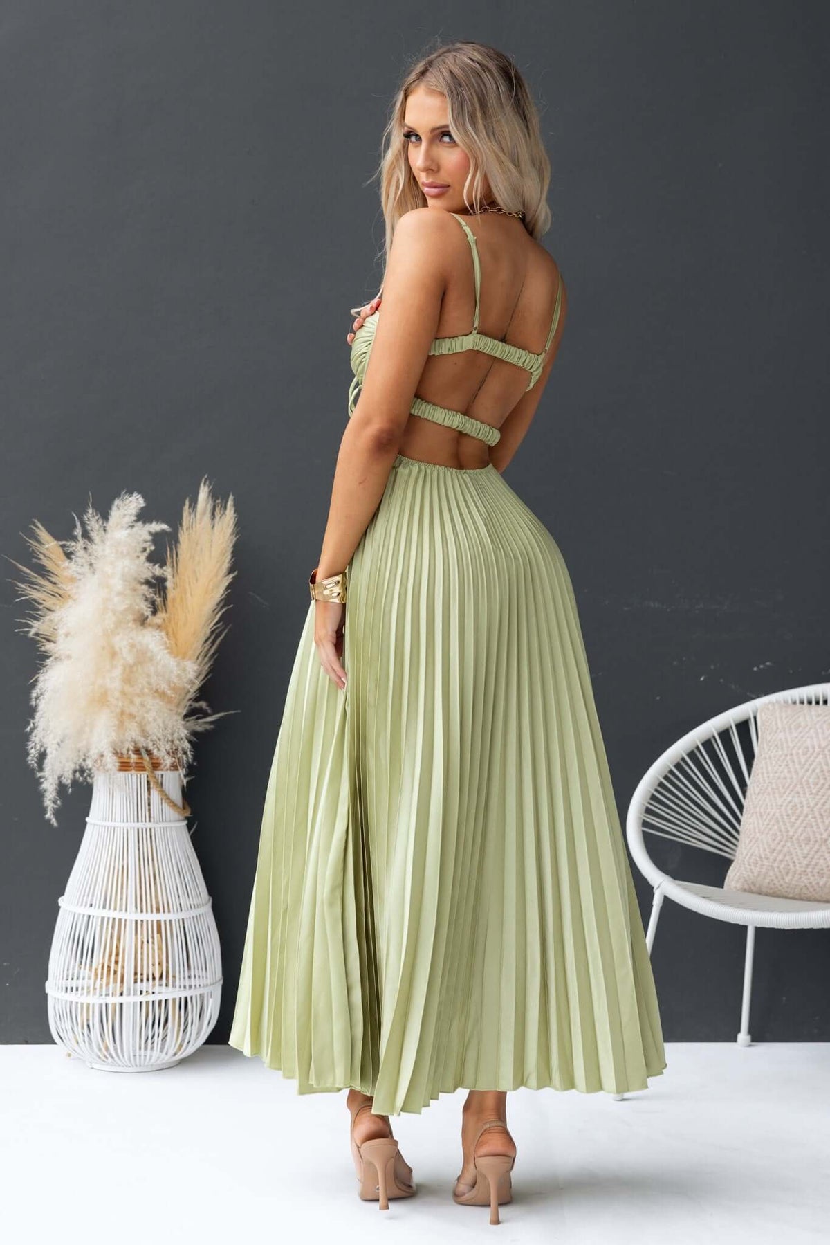 Elegant back view of woman in Danette Maxi Dress with pleated skirt and adjustable straps, styled for summer fashion.