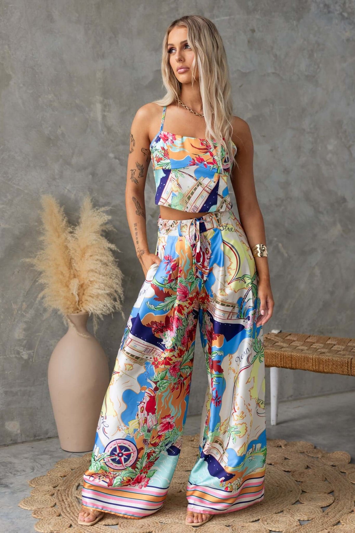 Model wearing colorful Saluzzo Pants with a matching top, showcasing mid-high waist and vibrant patterns.