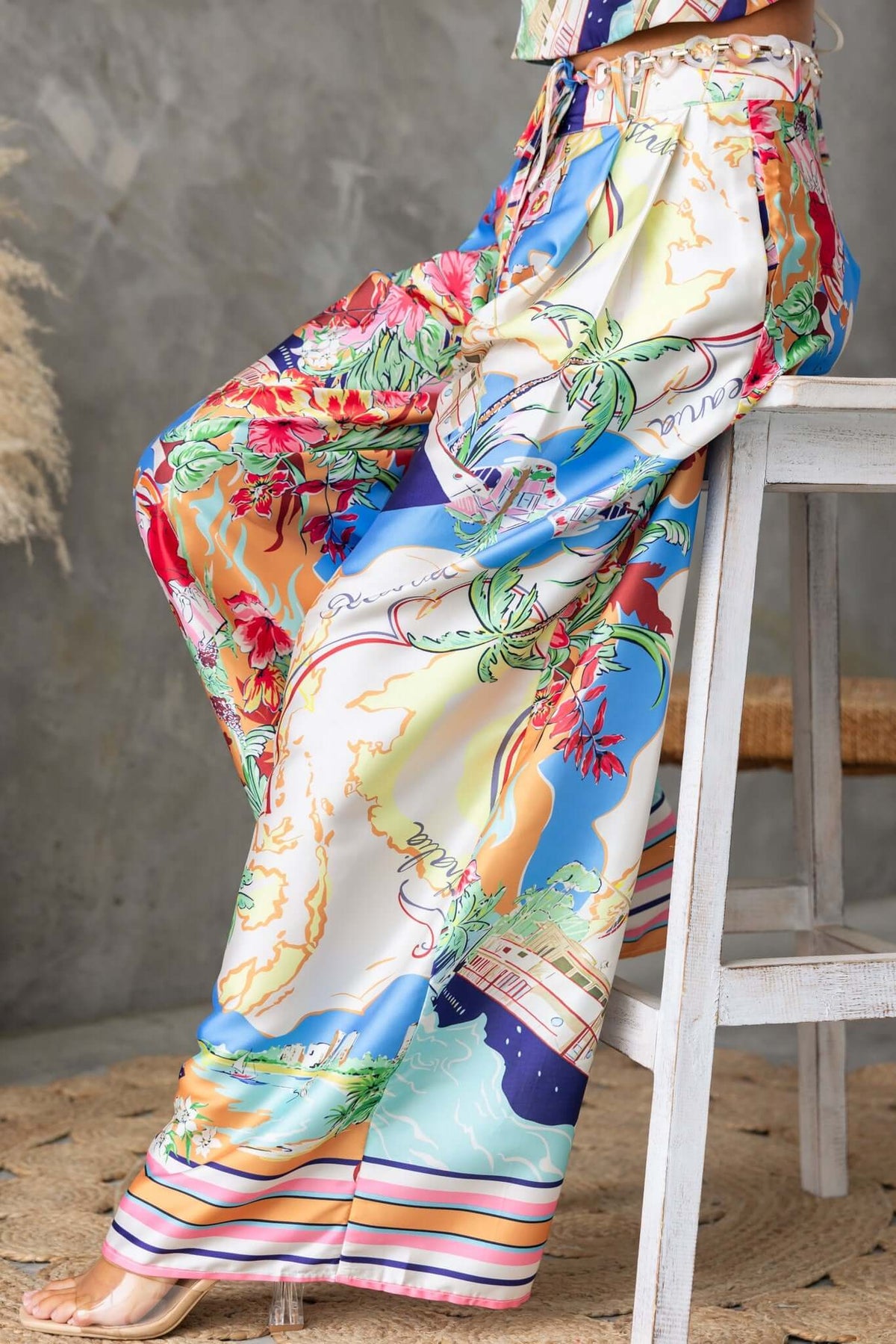 Colorful Saluzzo Pants featuring a mid-high waist, removable belt, and tropical print illustration.