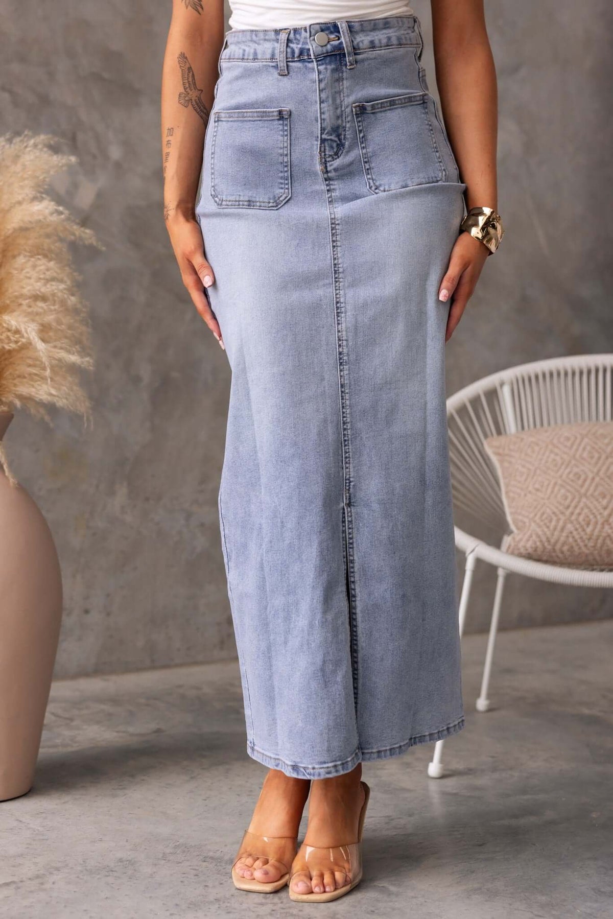Naomi denim maxi skirt with pockets and front split, styled for a casual look against a neutral background.
