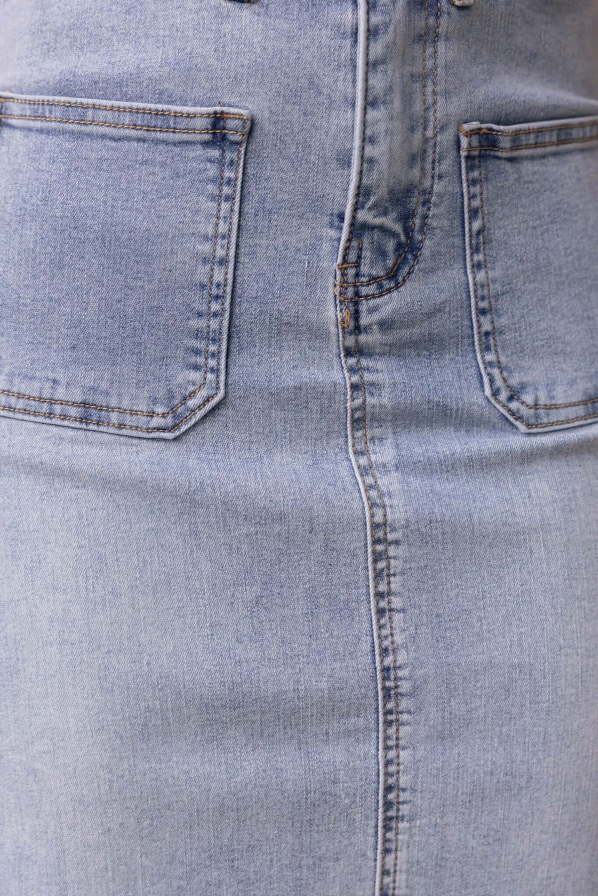 Close-up of Naomi Denim Maxi Skirt featuring mid-high waist, pockets, and front split design in light blue denim.