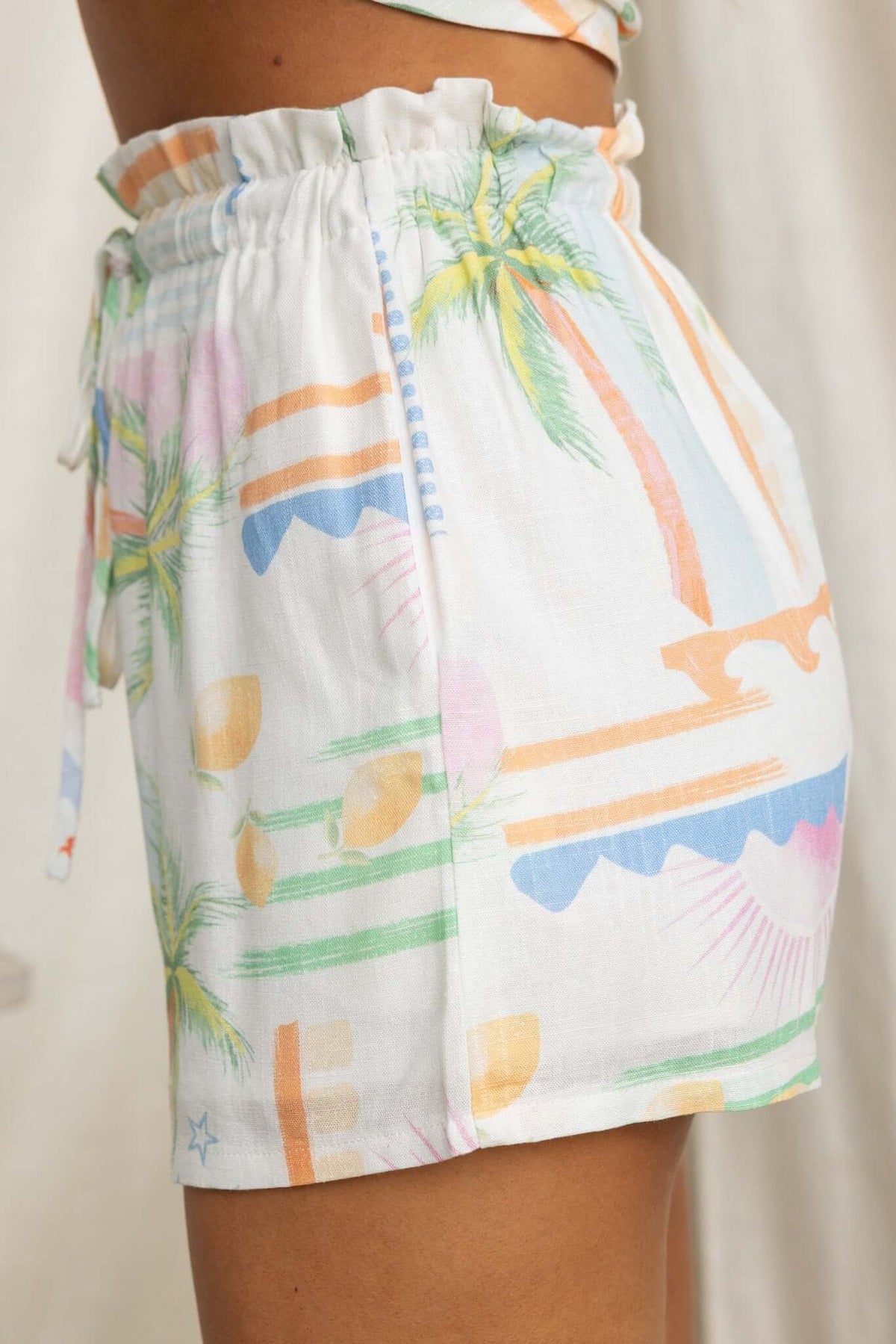 Glint Shorts featuring a mid-high waist, elastic waistband, and colorful palm tree print design.