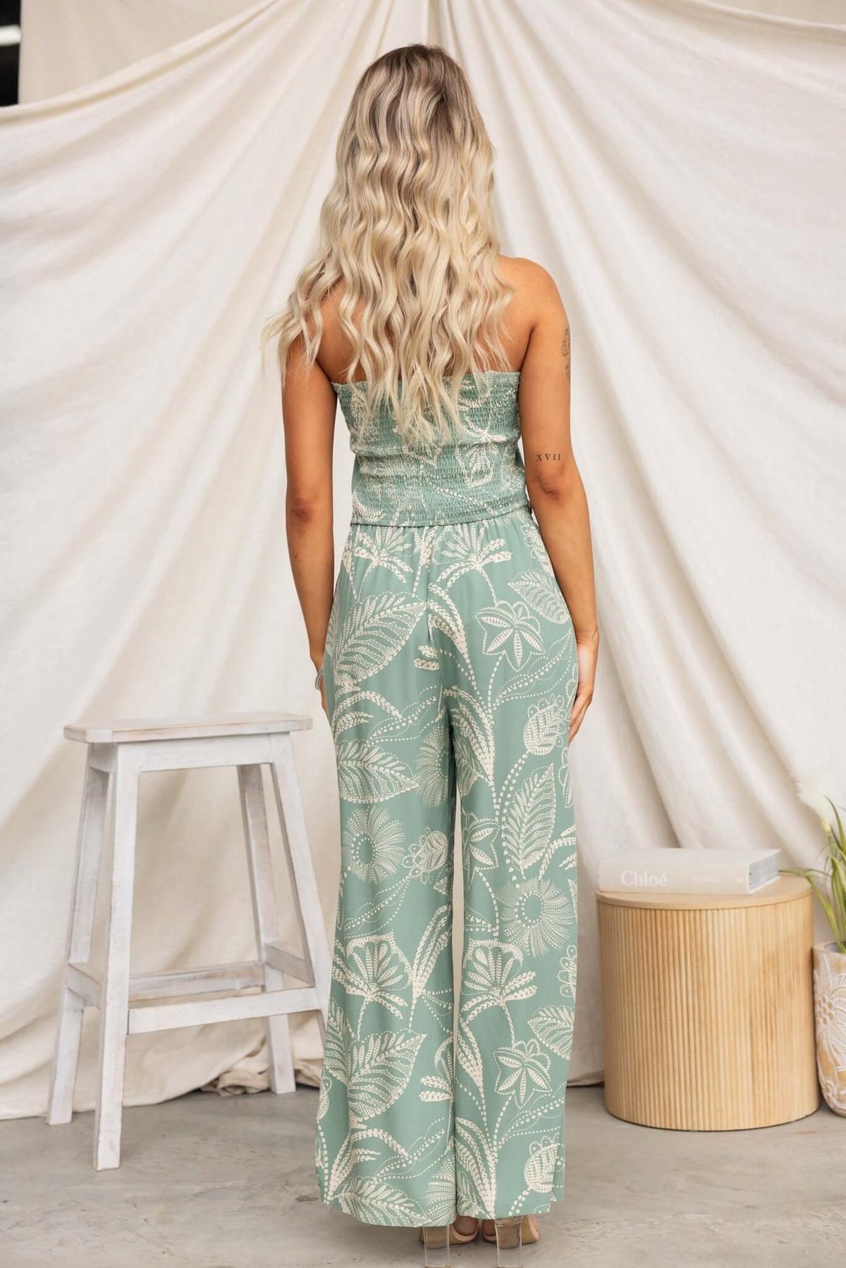 Model wearing a mint green strapless Lasan Set with patterned wide-leg pants, showcasing a relaxed, stylish look.