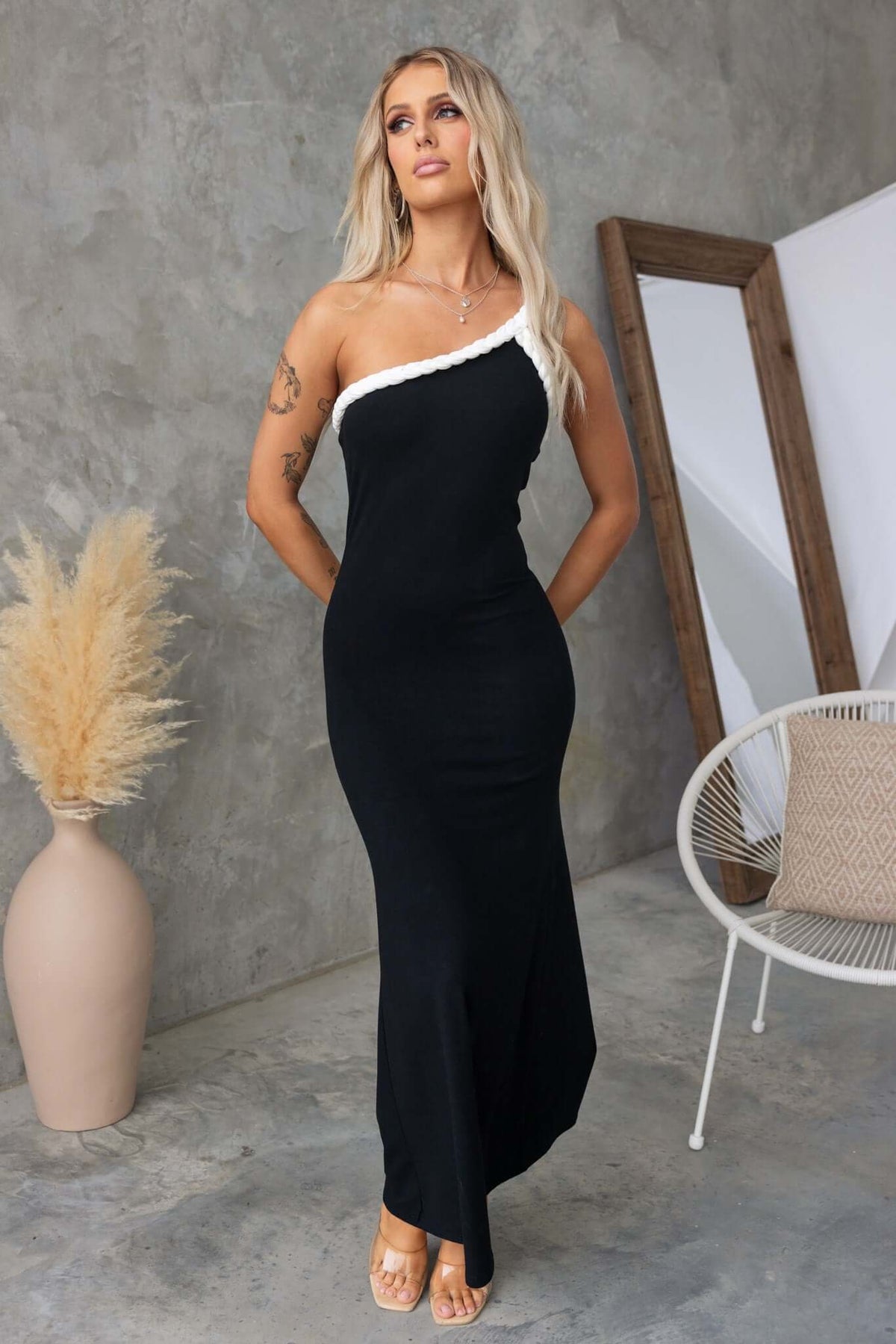 Model wearing a black Sabyna Maxi Dress with a one-shoulder neckline and ribbed material, showcasing a fitted silhouette.