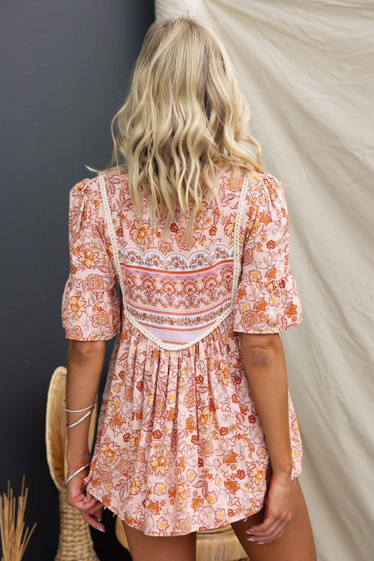Back view of the Kyra Top featuring a floral print, V-neckline, and tie detail, worn by a model with blonde hair.