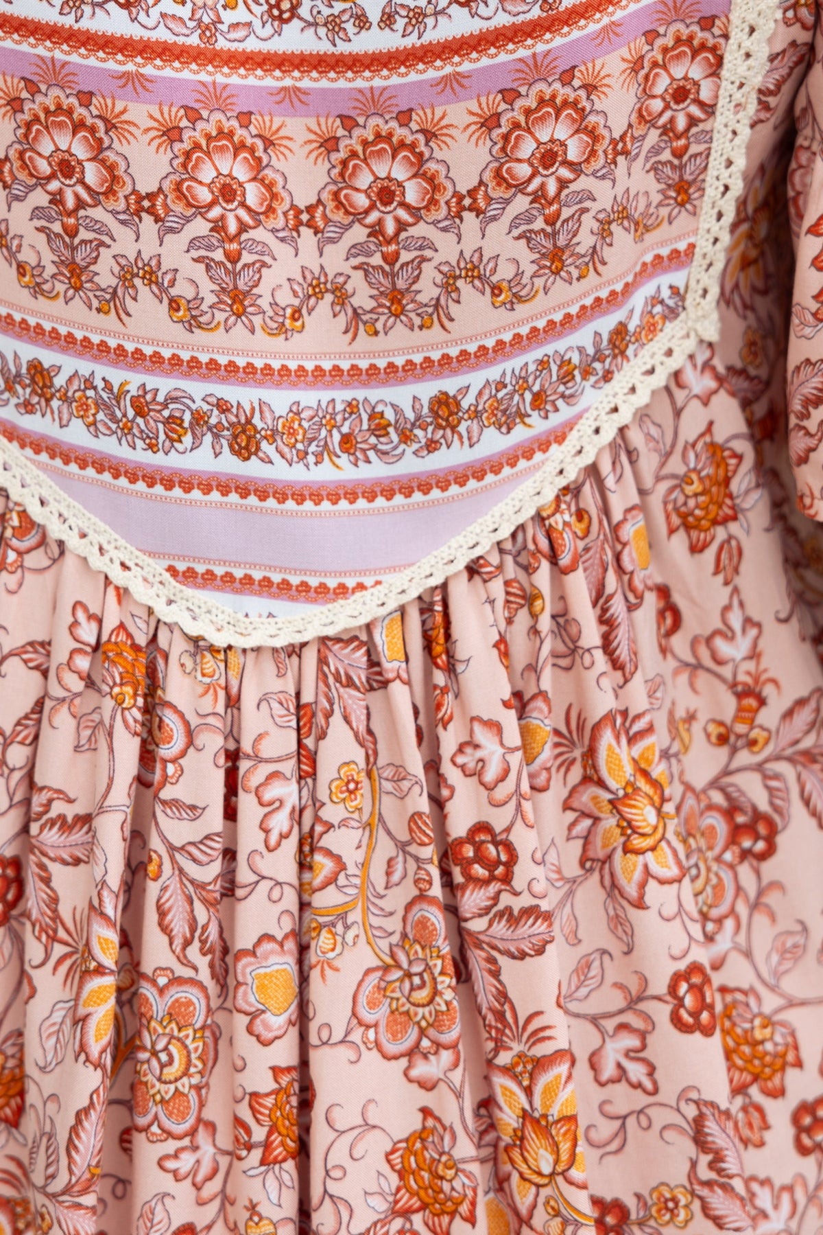 Floral print fabric of the Kyra Top featuring a V-neckline and tie detail, showcasing vibrant colors and intricate patterns.