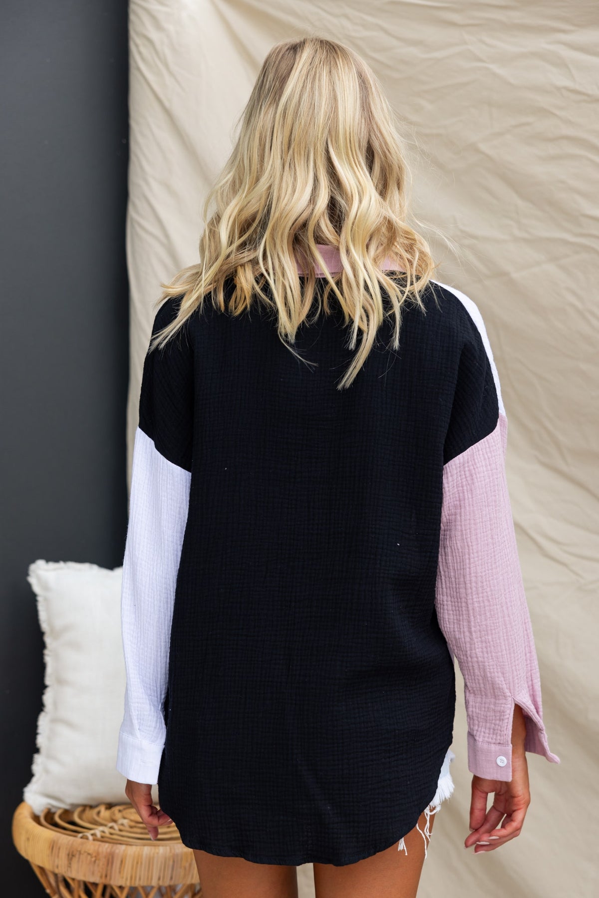 Back view of Atticus Top: oversized black cotton shirt with pastel sleeves, highlighting its relaxed fit.