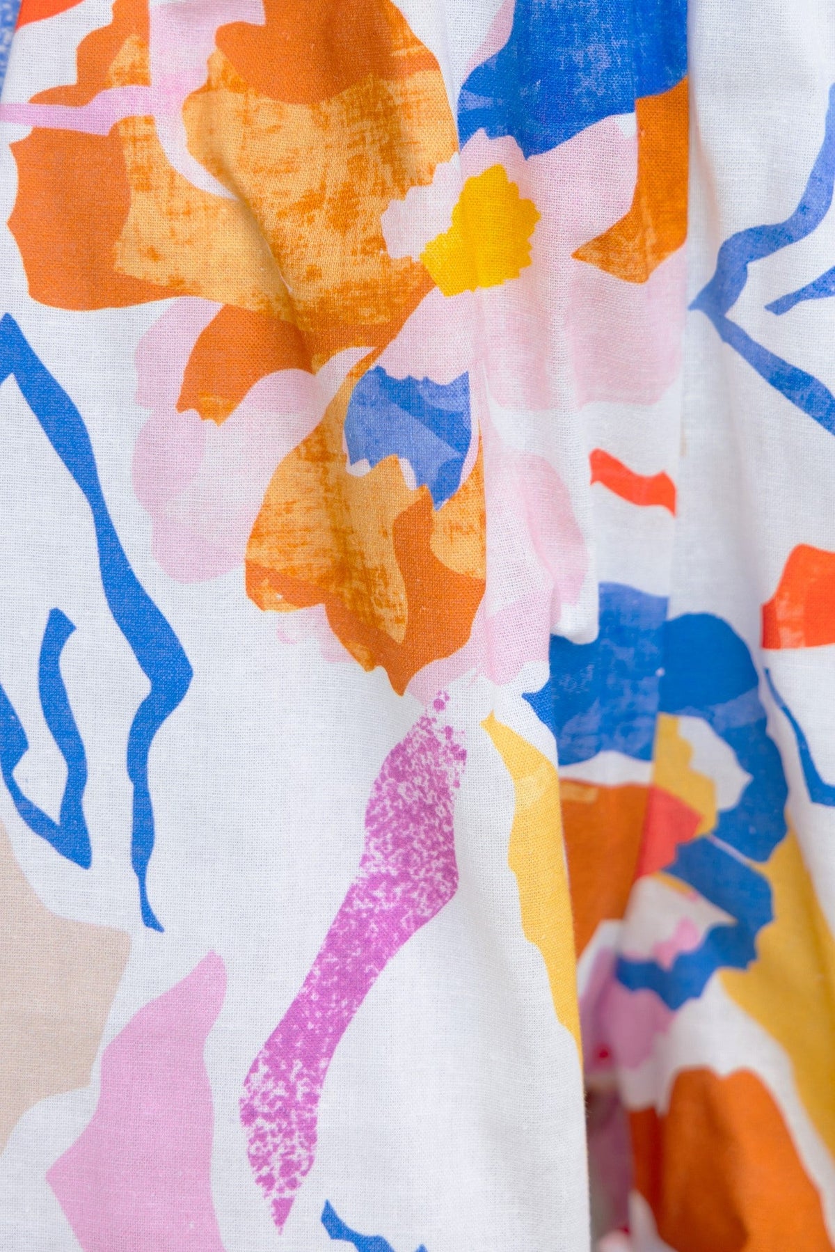 Close-up of colorful floral print fabric featuring vibrant orange, pink, and blue flowers ideal for Bonito Shorts.