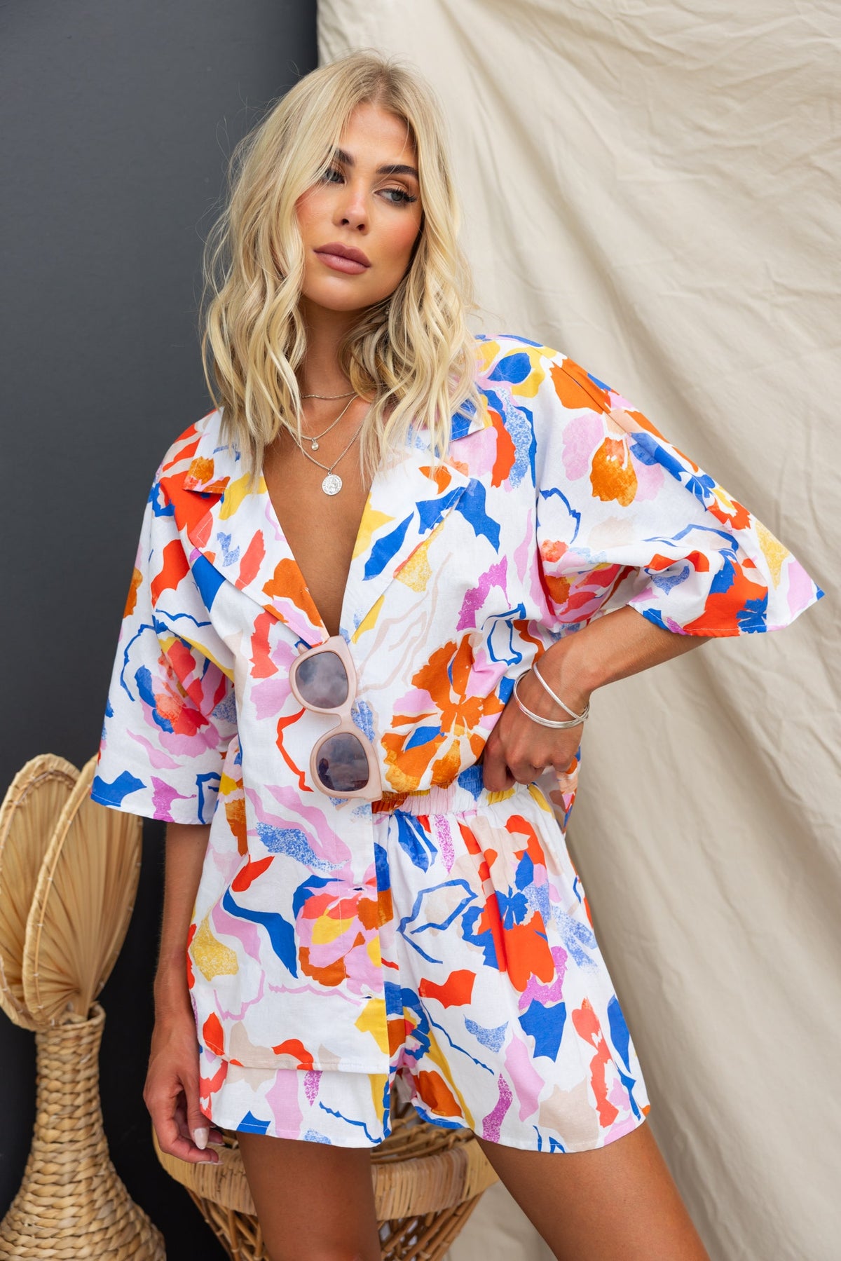 Model wearing Bonito Shorts with a floral print, mid-high waist fit, and elastic waistband, styled with sunglasses.