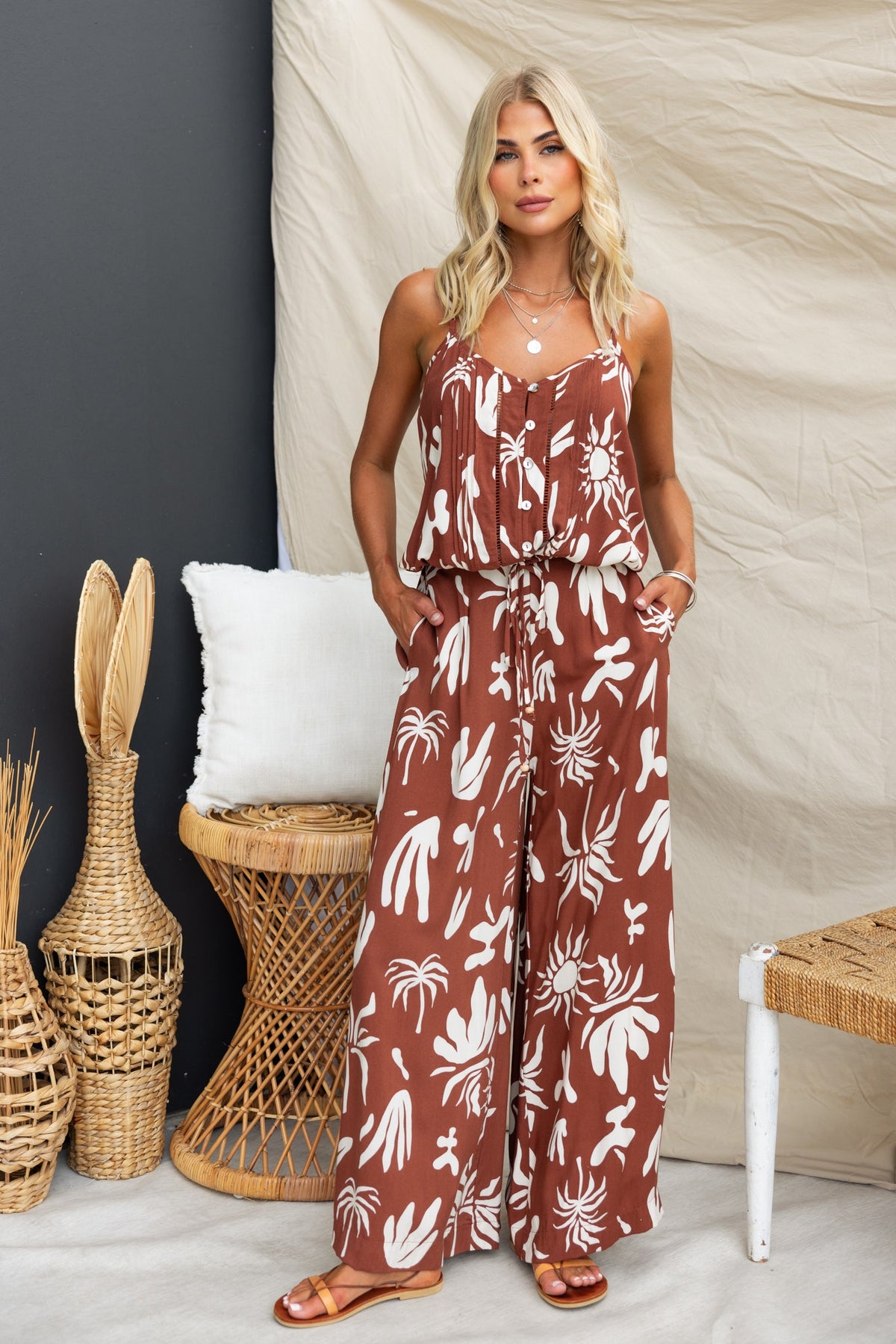 Model wearing abstract print Ethan Pants with mid-high waist and pockets, styled in a bohemian setting.