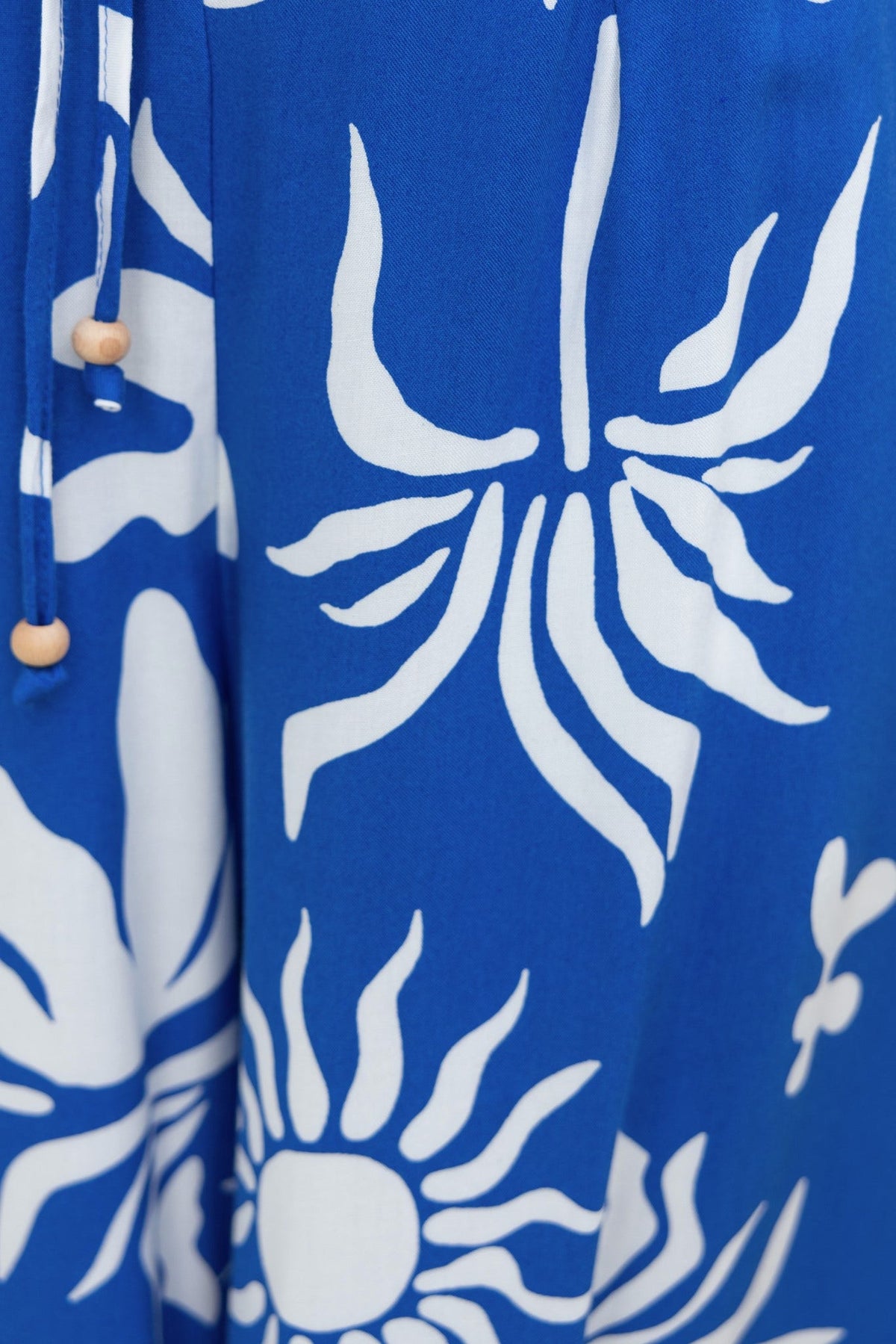 Close-up of abstract blue and white print on fabric, highlighting floral design elements in a stylish, lightweight material.