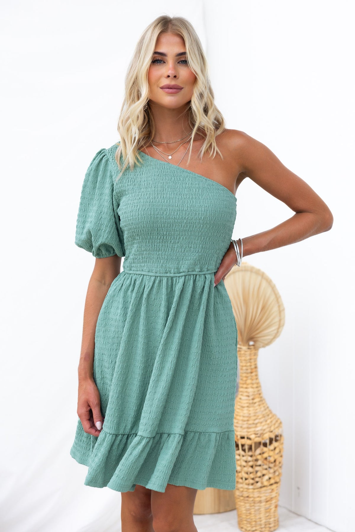 Galvez Dress in green with one-shoulder design, smocked bodice, and puff sleeve, showcasing casual elegance.