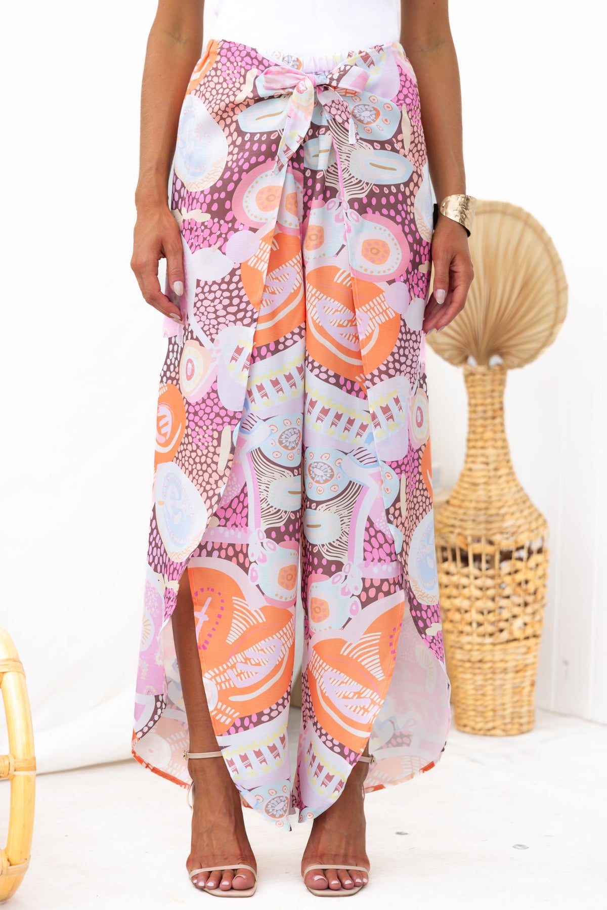 Kamilla Pants featuring an abstract print, mid-high waist, tie detail at waist, and front splits for a stylish look.