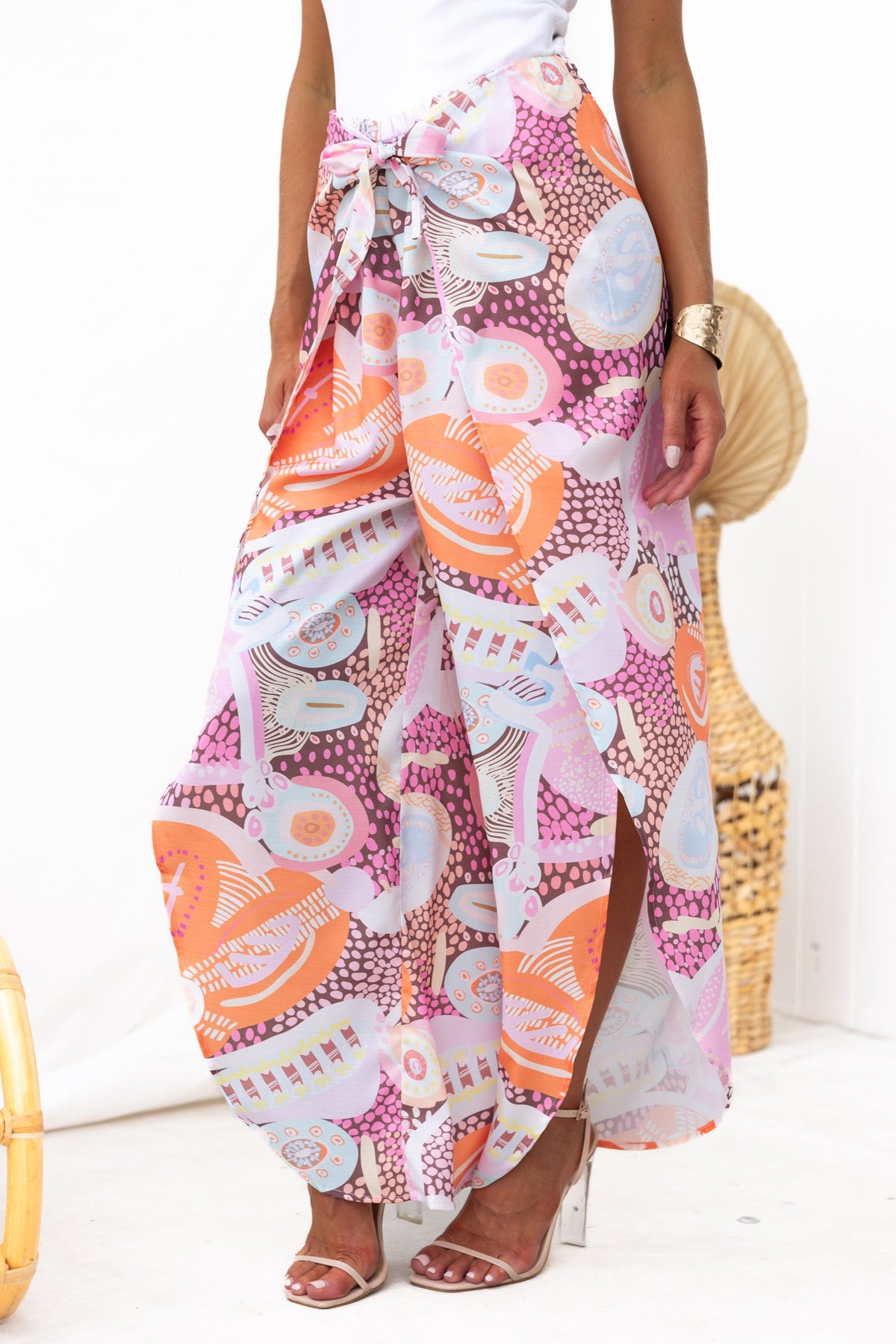 Kamilla Pants with abstract print, mid-high waist, tie waist, and front splits for a stylish summer look.