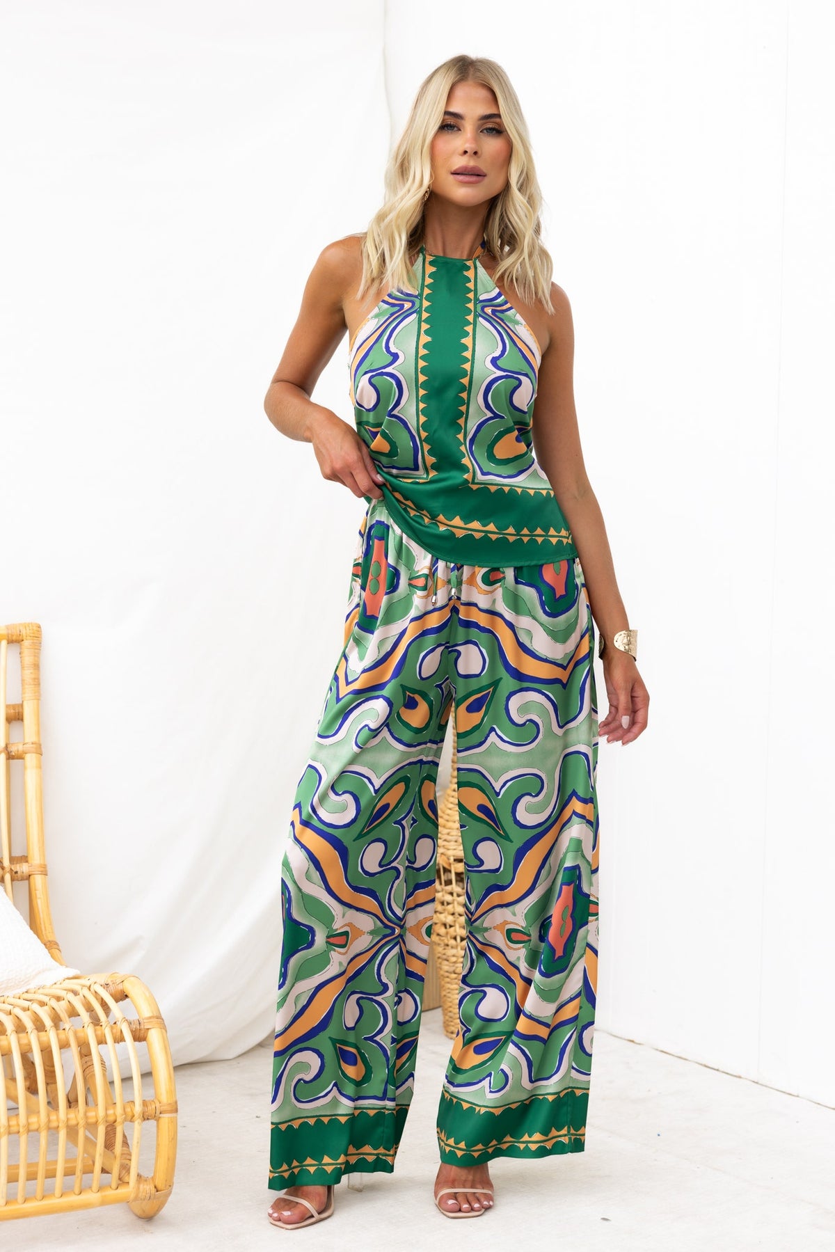 Model wearing the Up All Night Top with abstract print and adjustable halter neckline, styled with wide-leg pants.