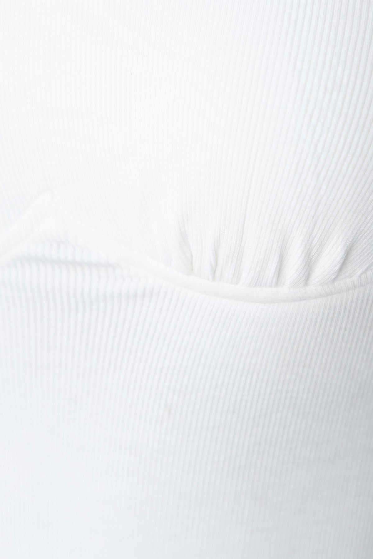 Close-up of Rhodes Bodysuit in white ribbed material, featuring a lined bust and stylish stretch design.