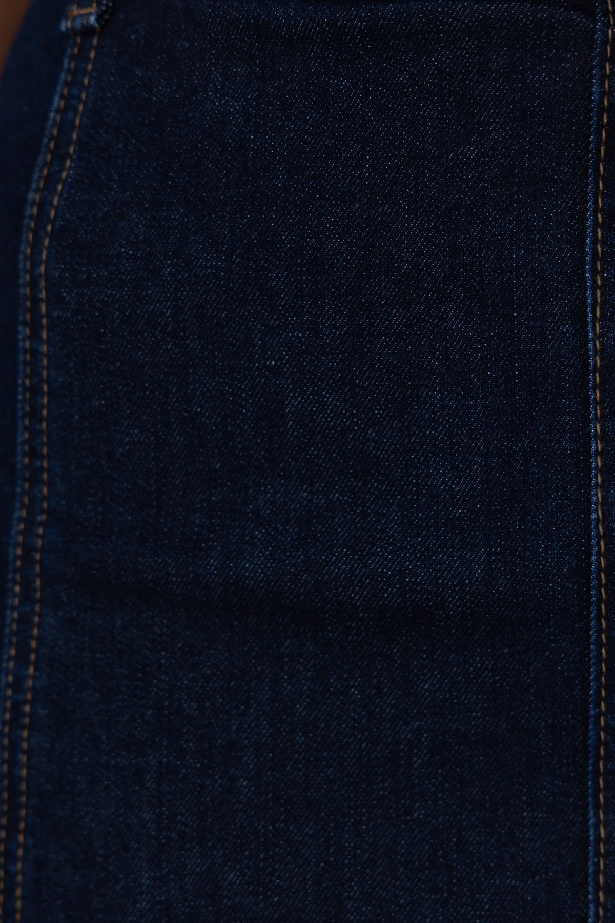 Close-up of dark navy denim fabric showcasing texture and stitching of Anni Denim Skirt.