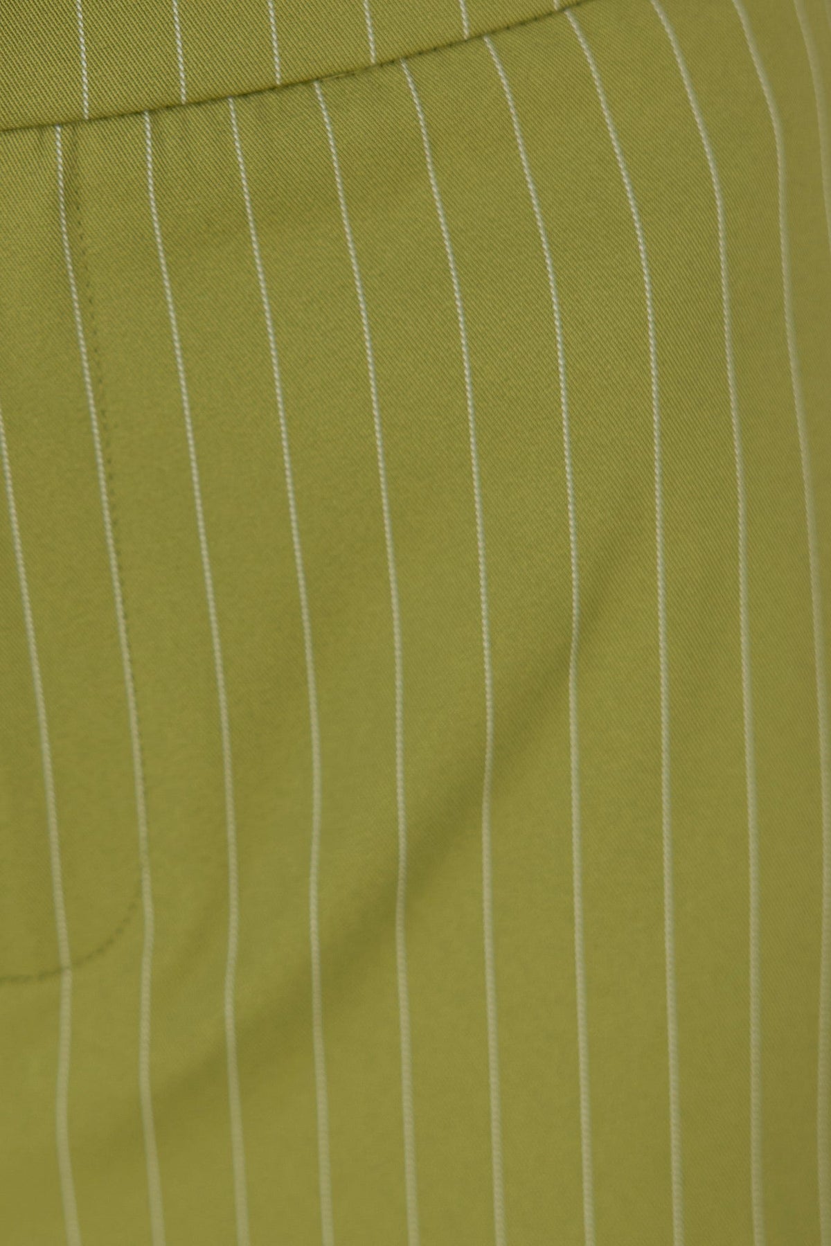 Close-up of the green striped fabric of Silvia Pants, showcasing the mid-high waist fit and stylish design.