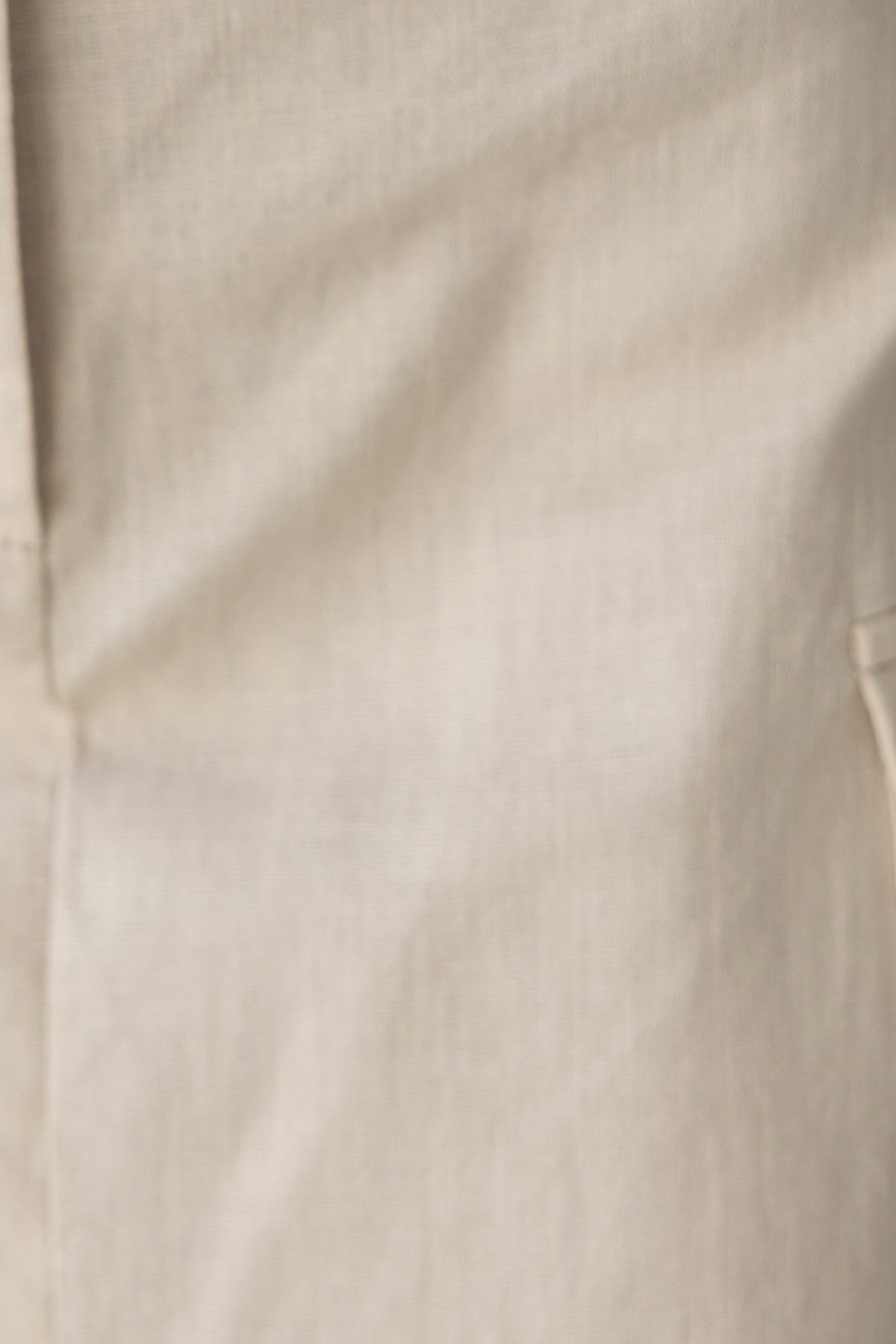 Close-up of Lyra Top's fabric texture in light beige, showcasing its cotton-like feel and smooth surface.
