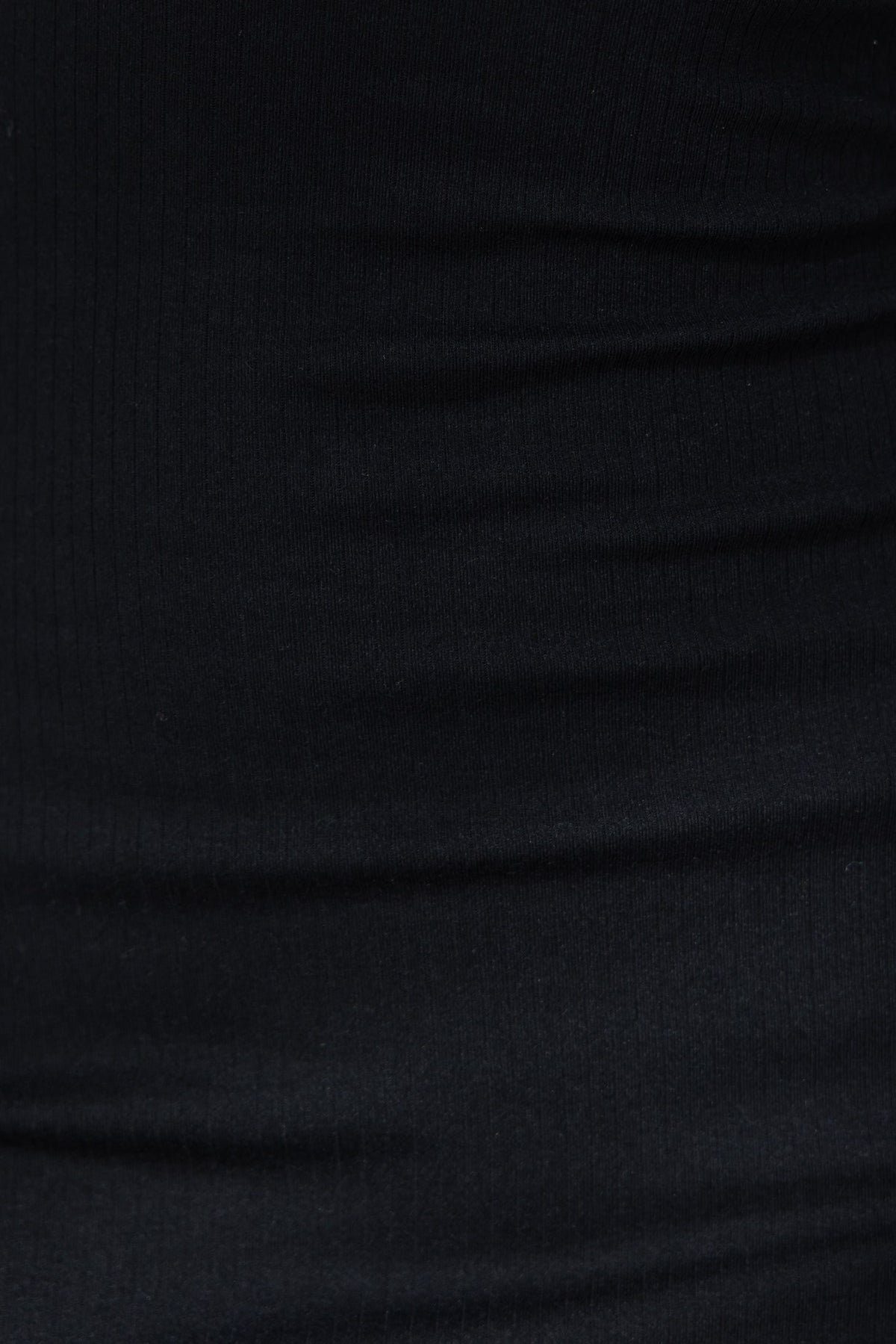 Close-up of lightly ribbed black fabric showcasing its stretch and texture, ideal for fashion and clothing products.