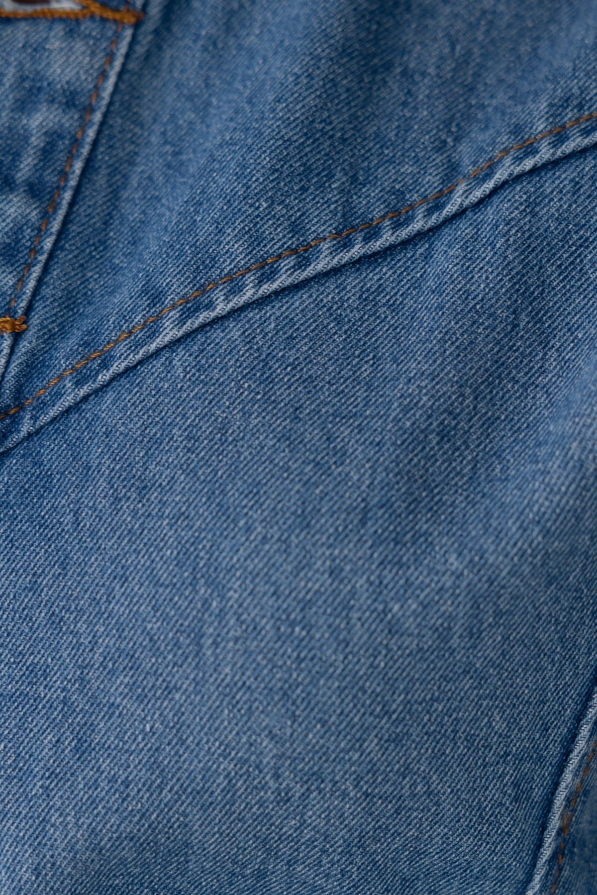 Close-up of blue denim fabric showcasing stitching and distressed details in Bonita Denim Dress.