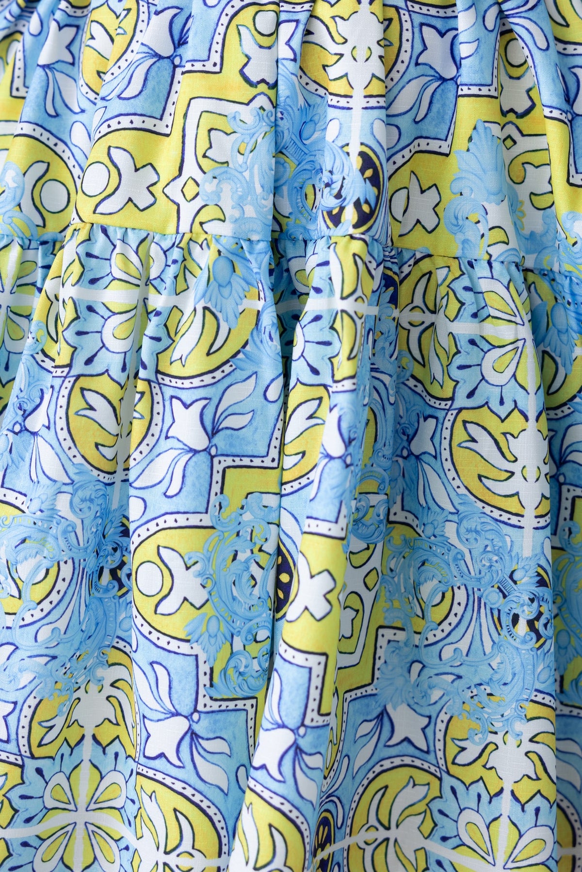 Colorful abstract print fabric of Stelle Dress featuring blue and yellow floral patterns.