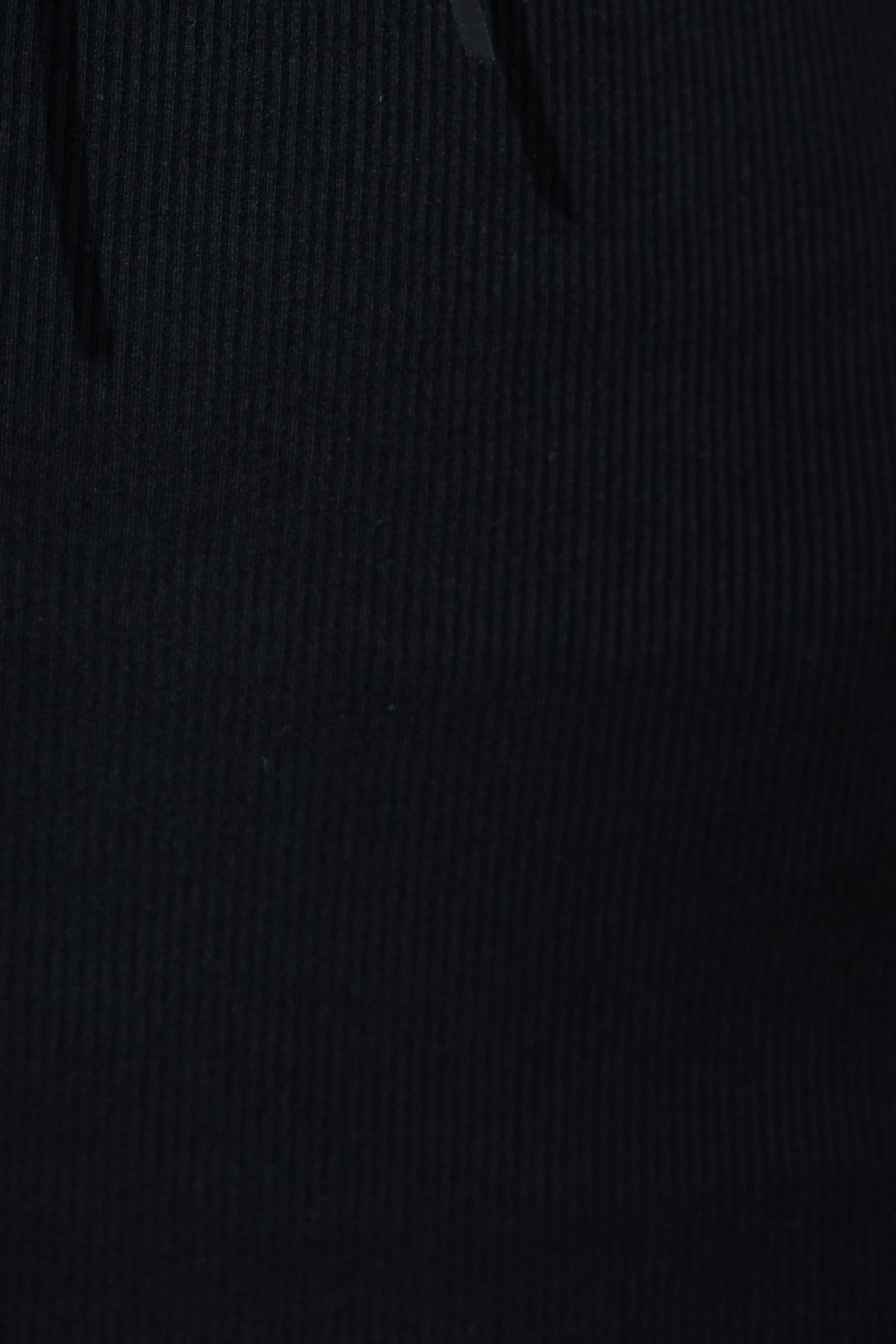 Close-up of black ribbed fabric texture, showcasing elasticity and detail for the Elaine Maxi Dress.