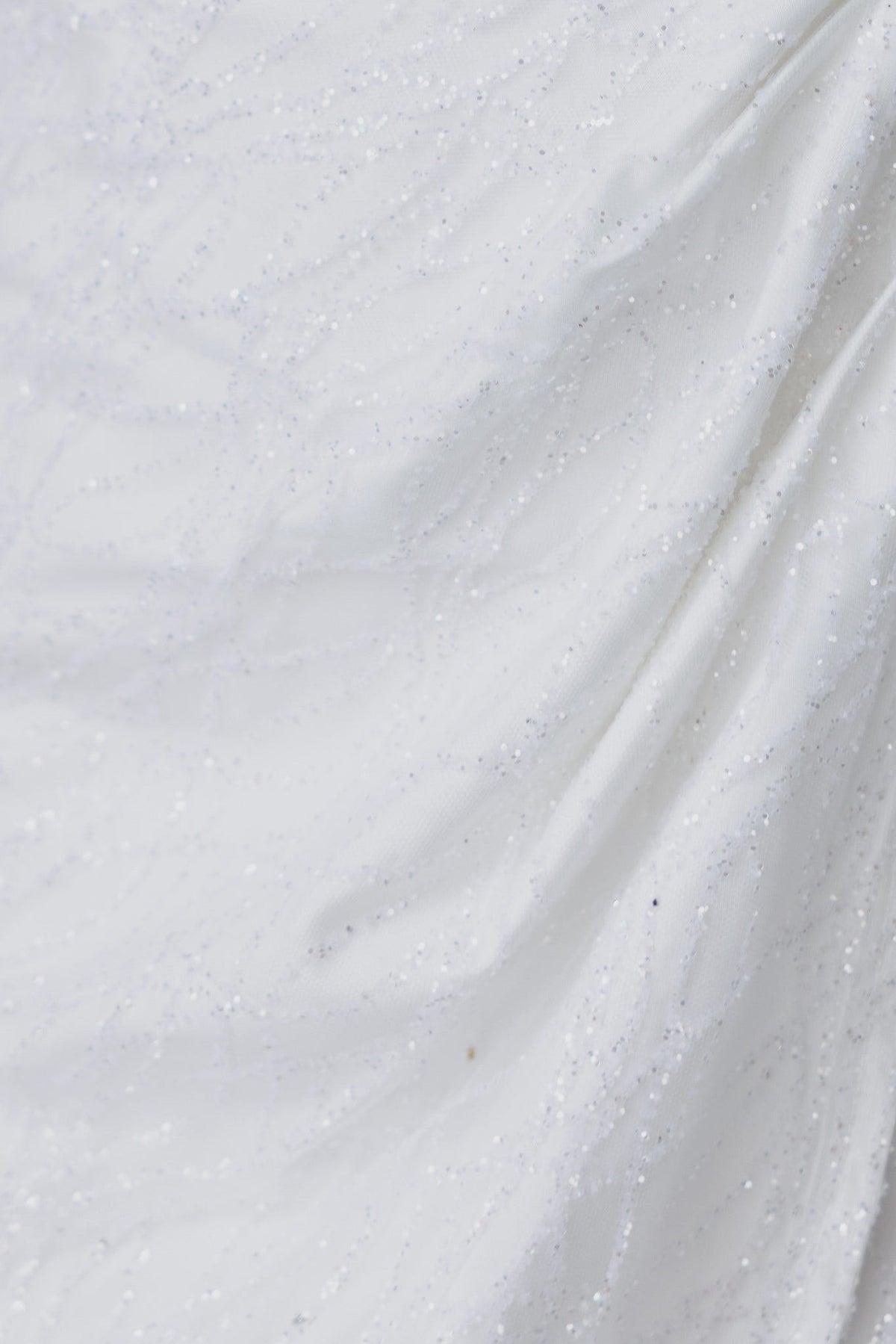 Close-up look at the glittery fabric of the Make It Rain Bodycon dress, featuring a luxurious sheen and elegant draping.