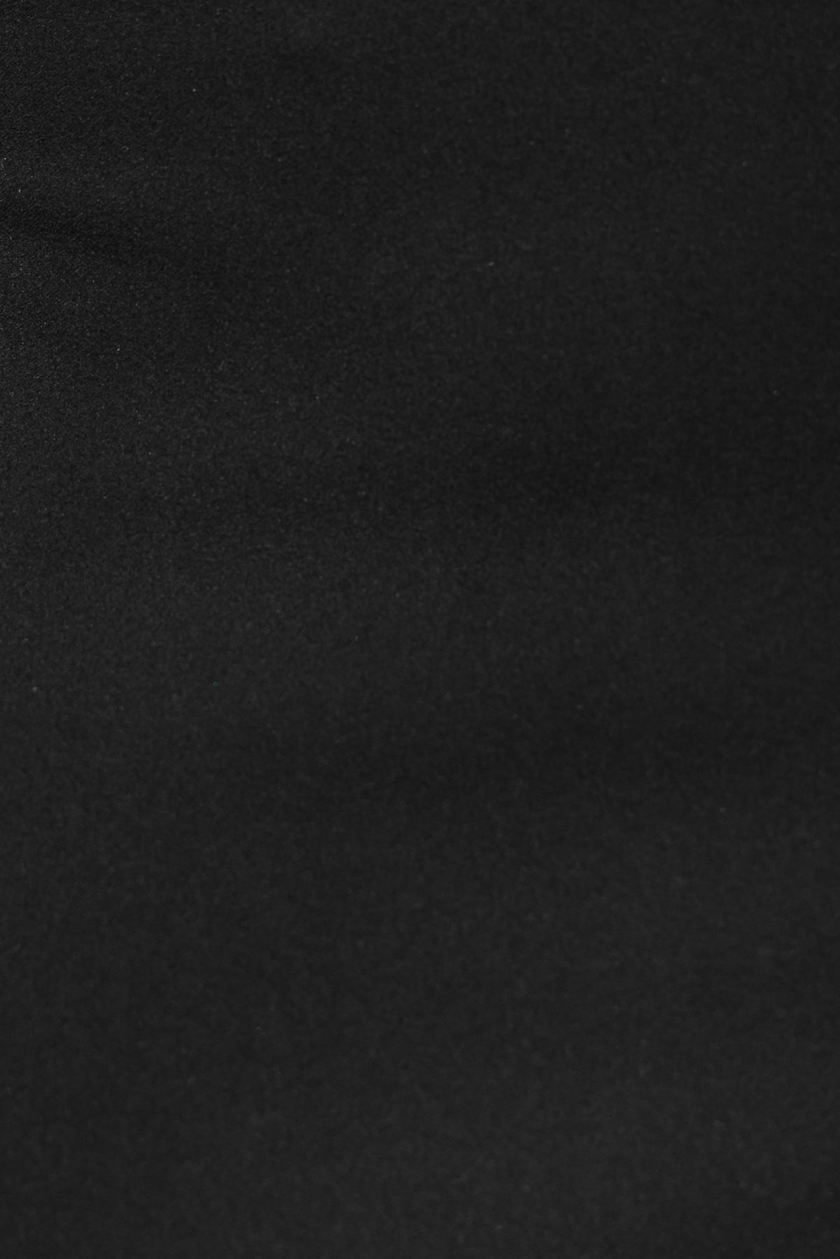 Close-up of black fabric texture, showcasing its smooth and stretchy material.