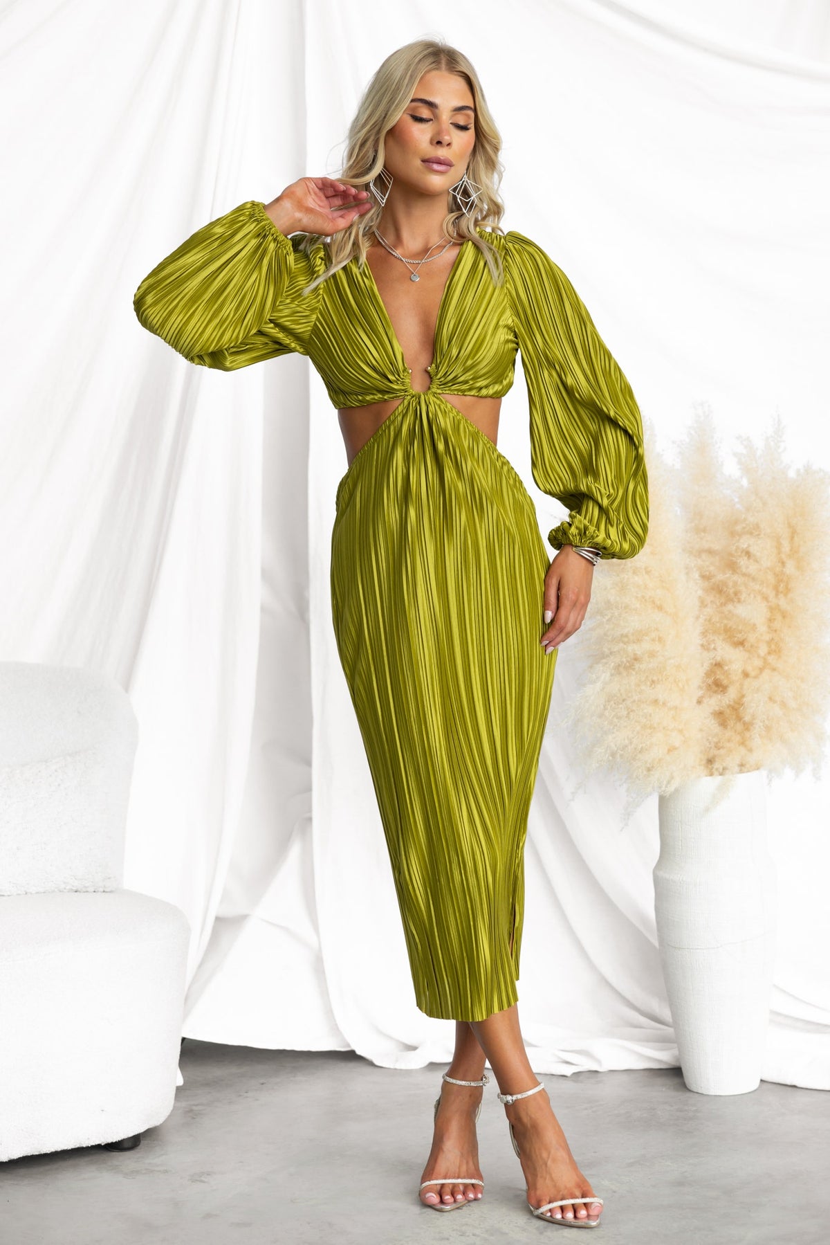 Aulia Midi Dress in vibrant green with pleated design, V-neckline, and side split, styled with gold accents.